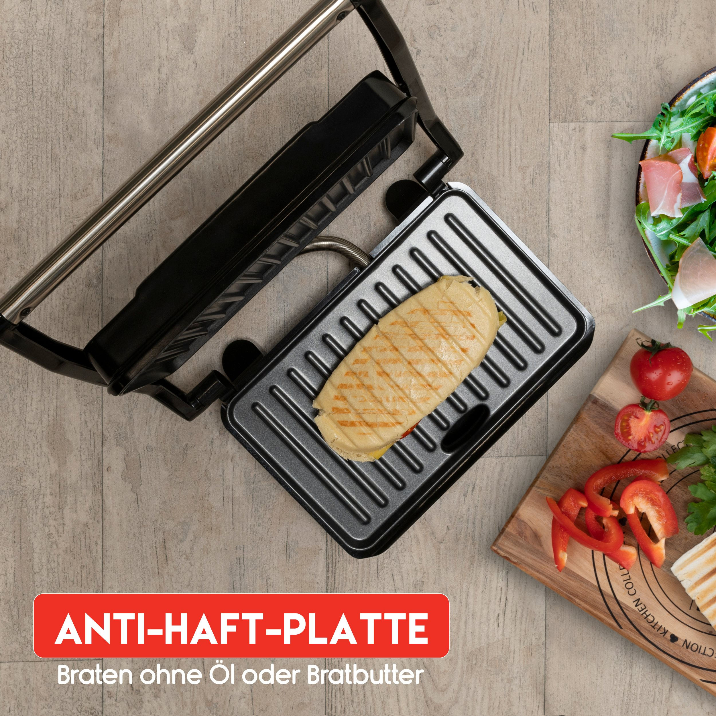 Sandwich in a black panini maker. Ingredients include tomatoes and peppers on a wooden board.