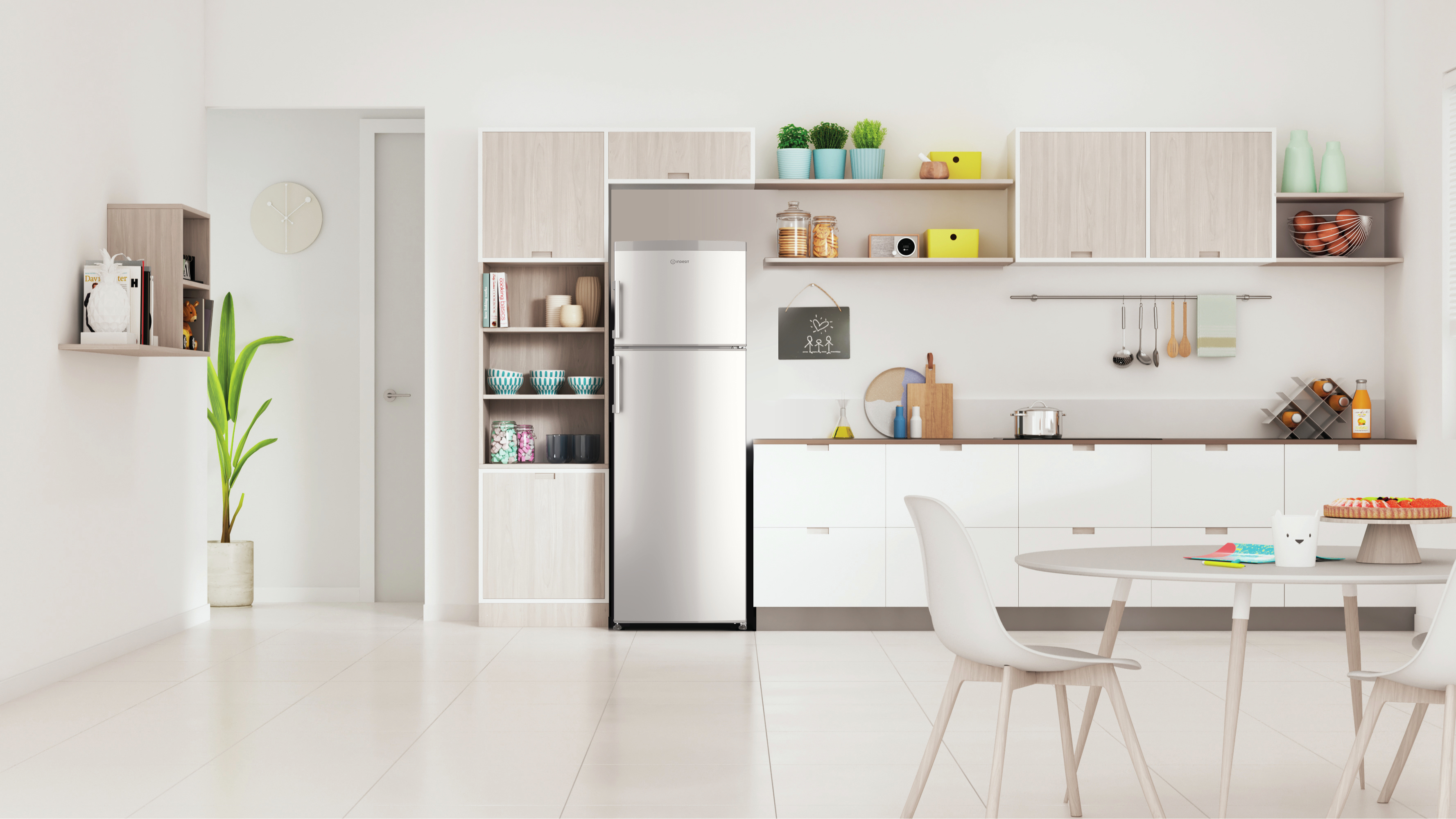 Interno cucina moderno con mobili bianchi, frigo, tavolo rotondo e sedie.
