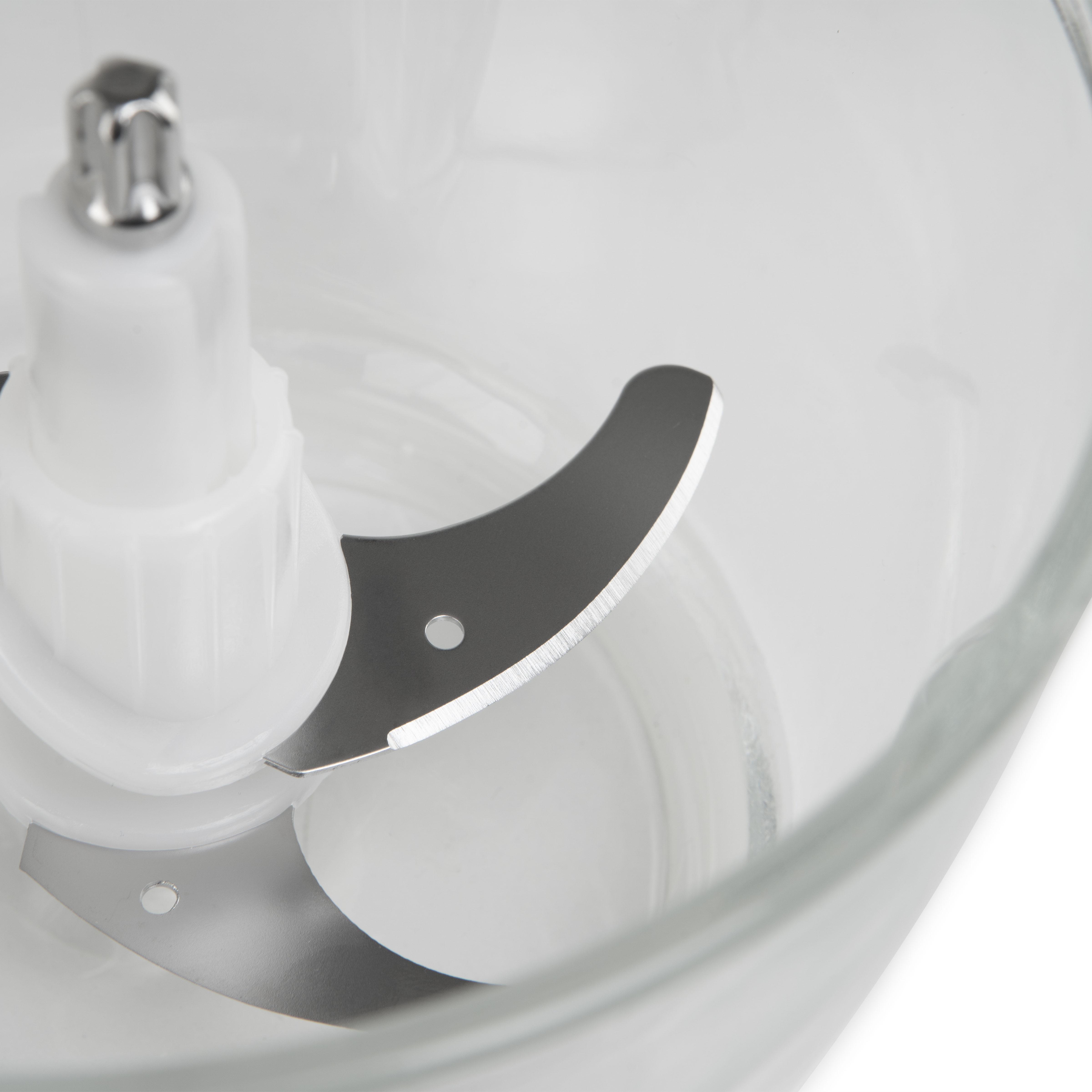 Cuchillas de procesador de alimentos, primer plano. Cuchillas de acero inoxidable en bol transparente.