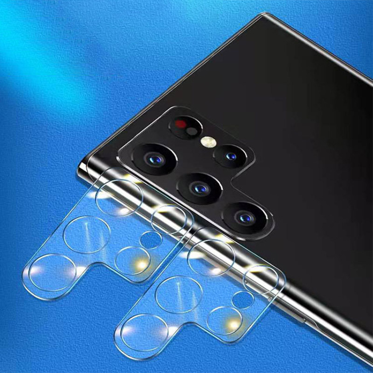 Due protezioni trasparenti per lenti della fotocamera sul retro di un telefono nero. Le lenti sono visibili.