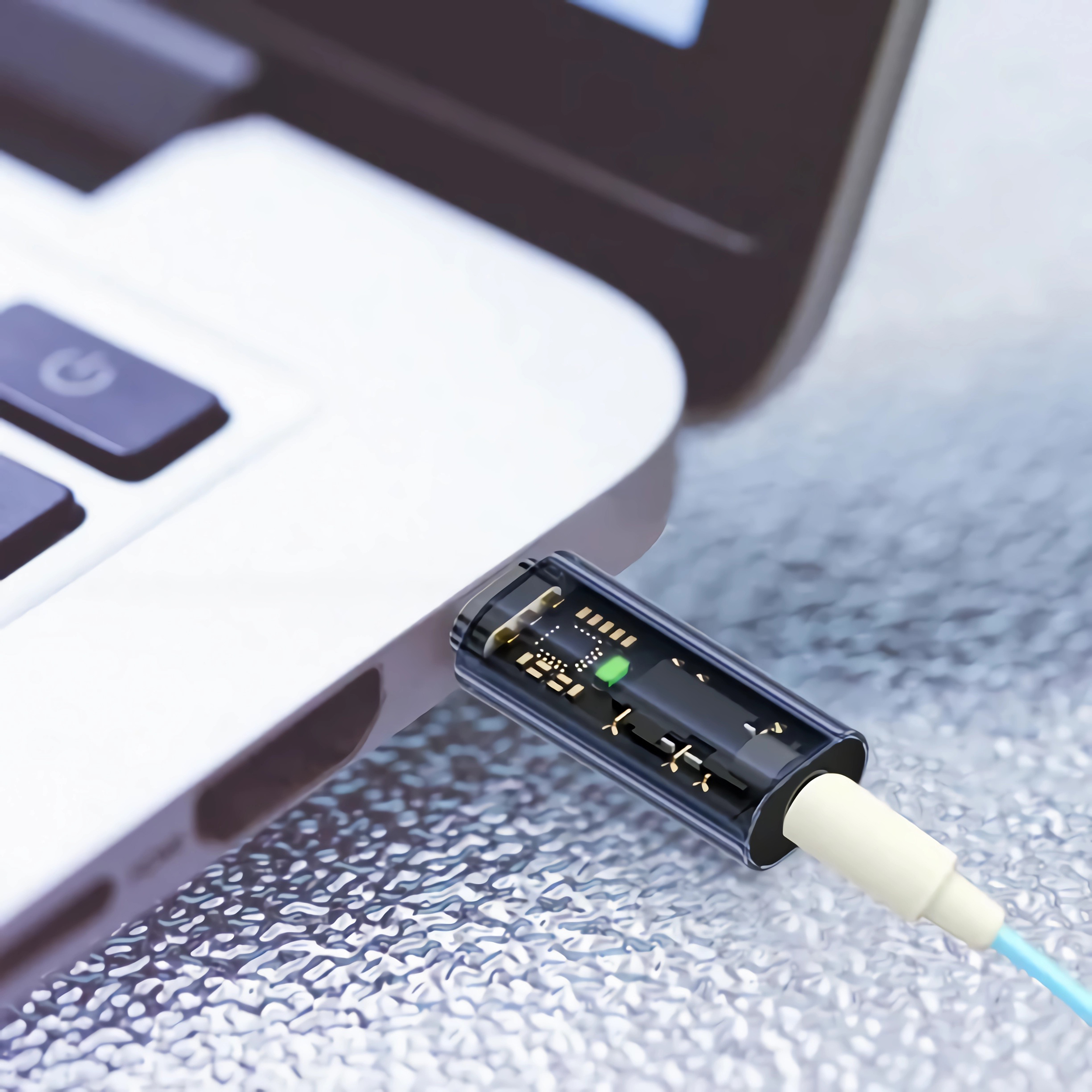 Ein USB-C-Kabel, das an einen Laptop angeschlossen ist. Das Kabel ist durchsichtig.