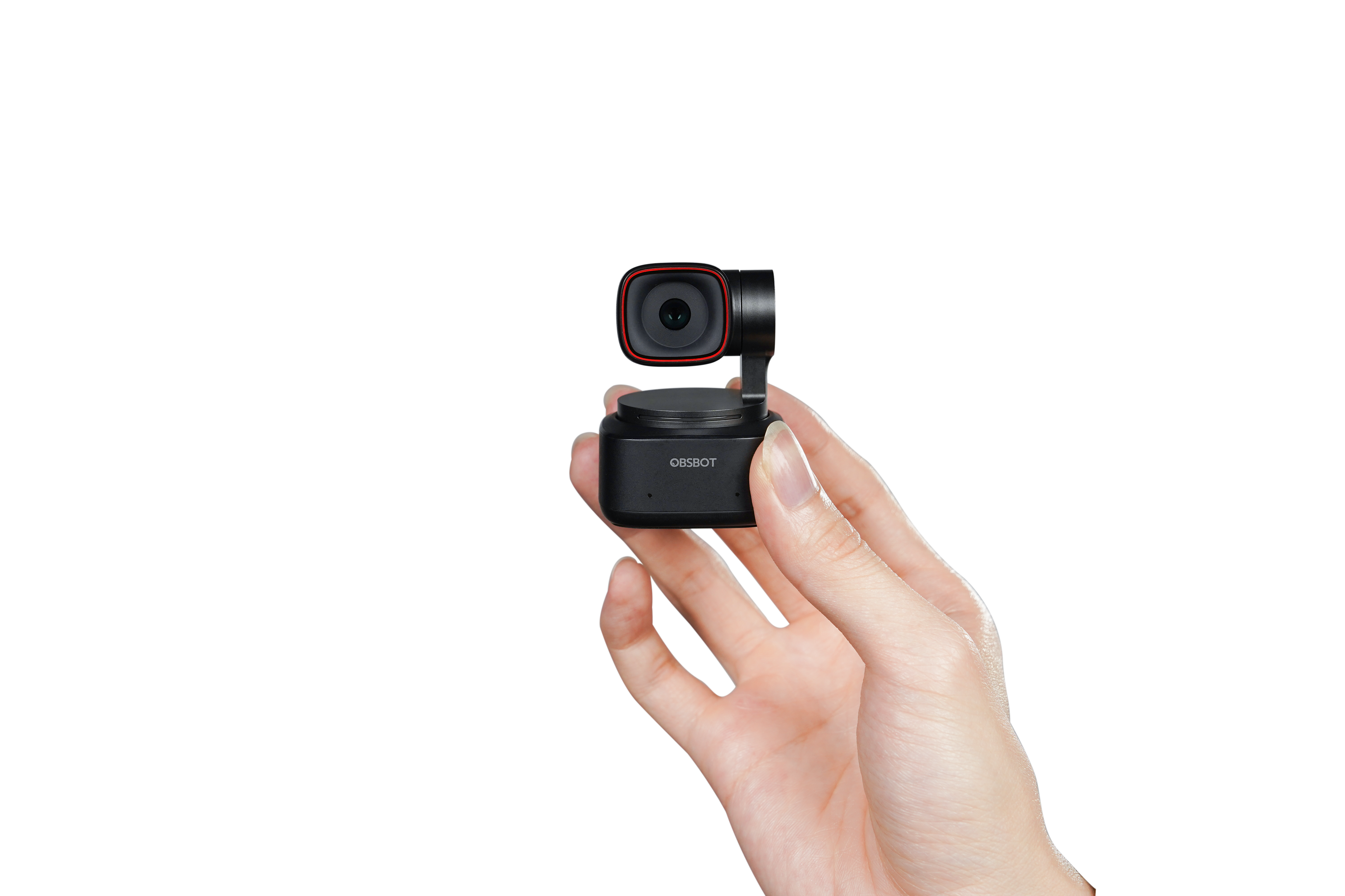 Osoba trzymająca małą czarną kamerę na całkowicie czarnym tle.