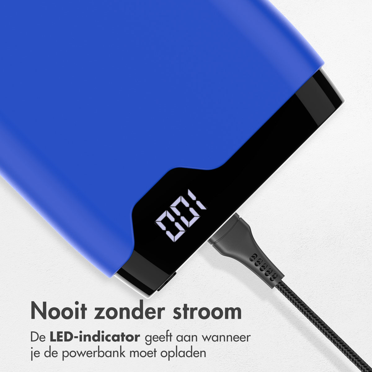 Blaue Powerbank mit Digitalanzeige, die 100 % anzeigt. Schwarzes Kabel angeschlossen. Text: Nie ohne Strom.