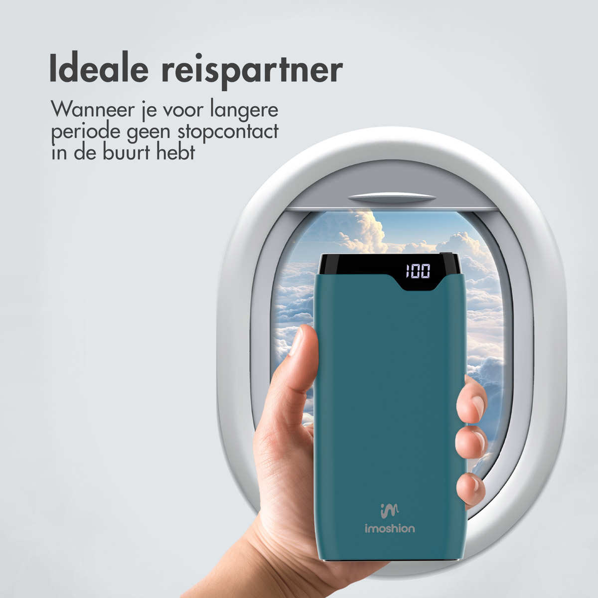 Hand hält Powerbank vor Flugzeugfenster, zeigt 100% Ladung.