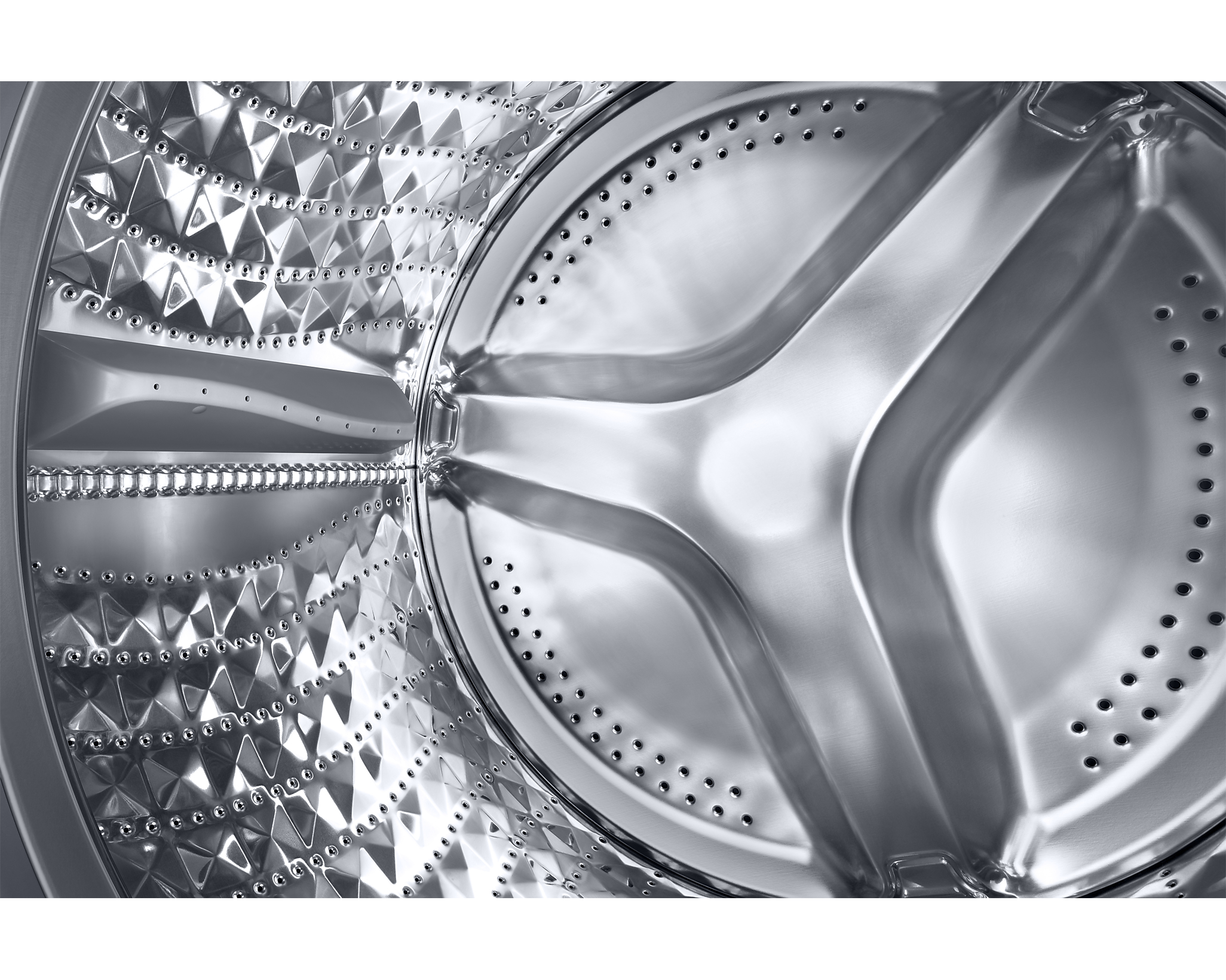 Close-up of a silver washing machine drum interior. Diamond-shaped textures, central cross design.