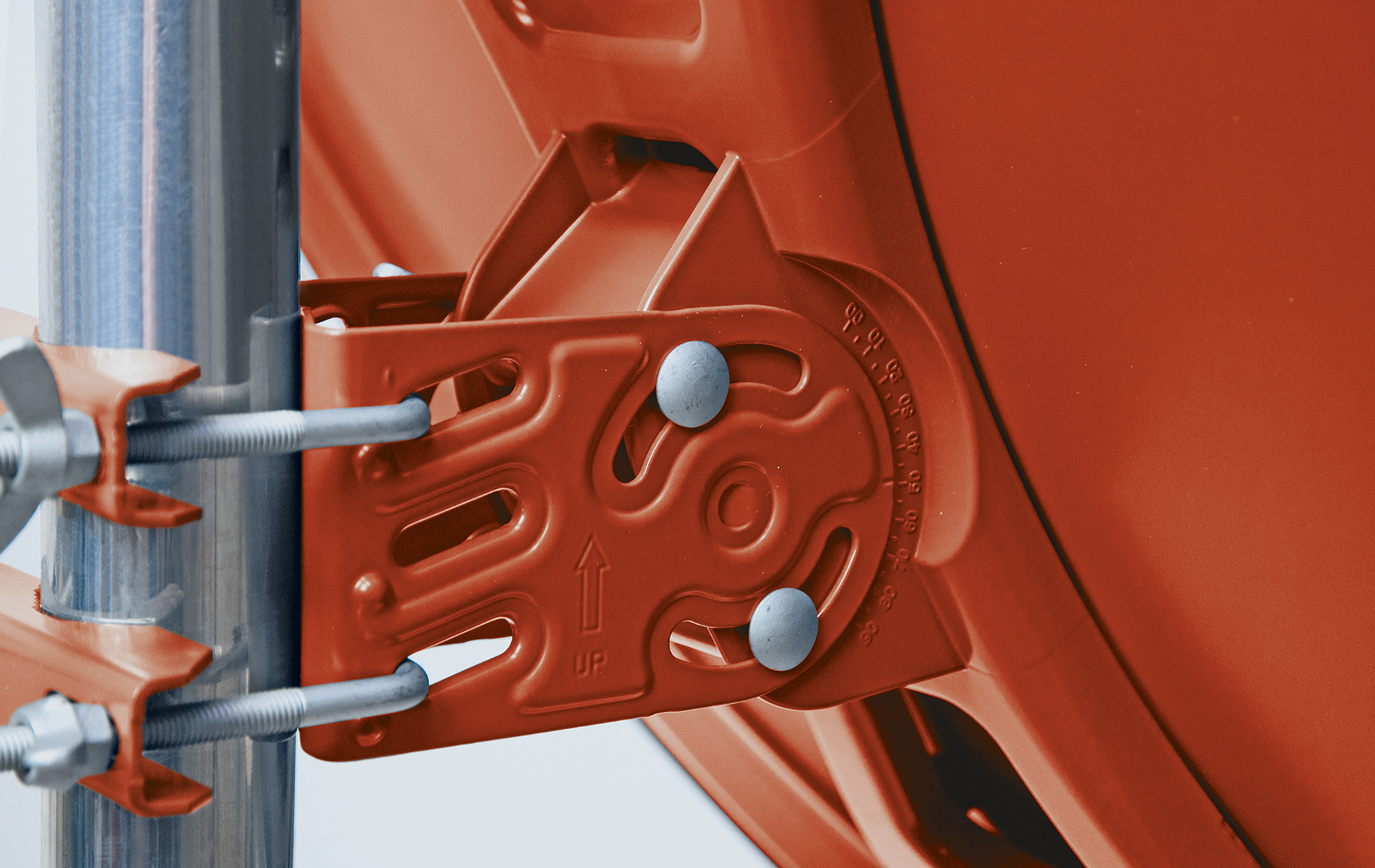 Eine rote, verstellbare Halterung an einem Metallpfosten mit Bolzen.