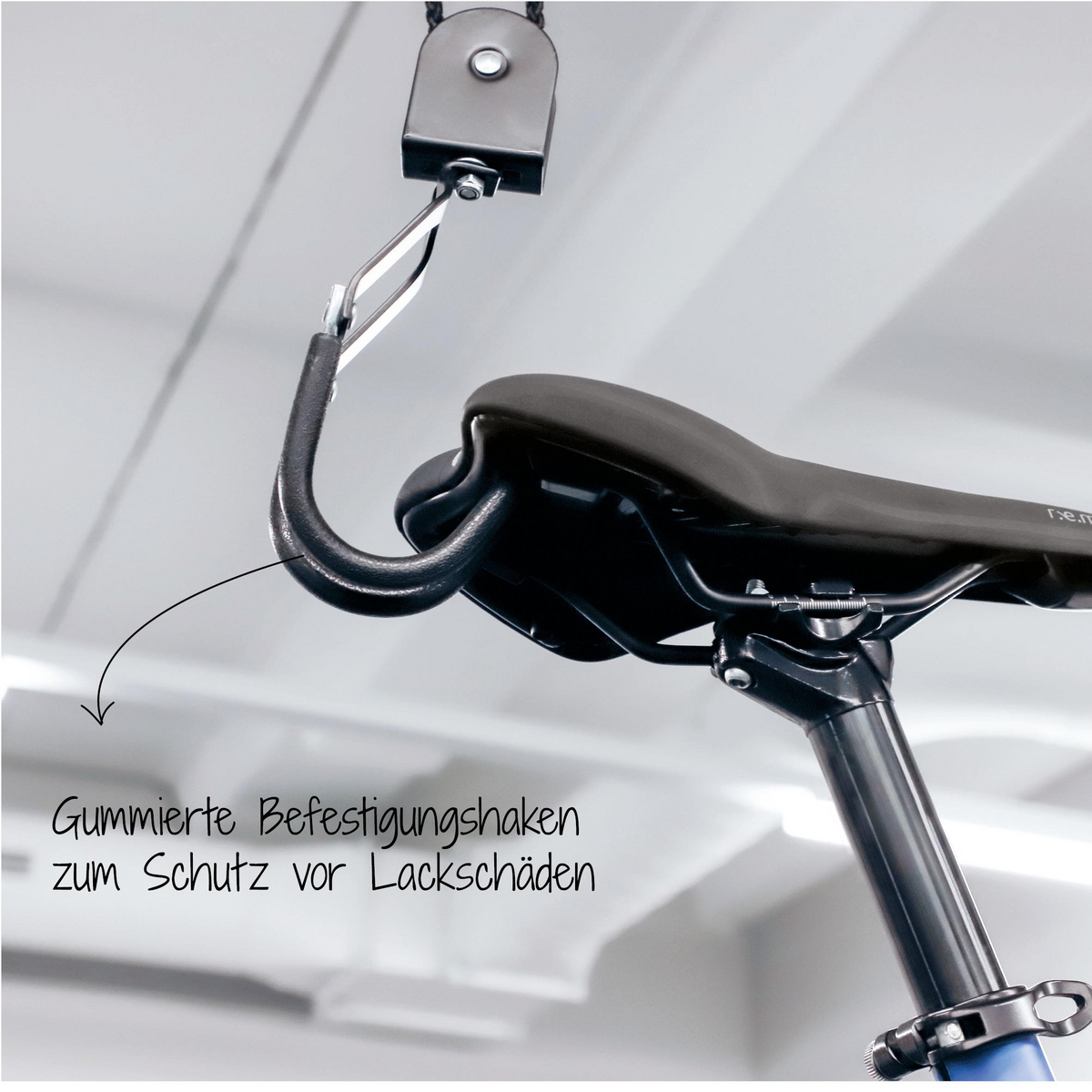 Ein Fahrradsattel, der an einer Deckenhalterung hängt, mit Text, der auf gummierte Haken zeigt.