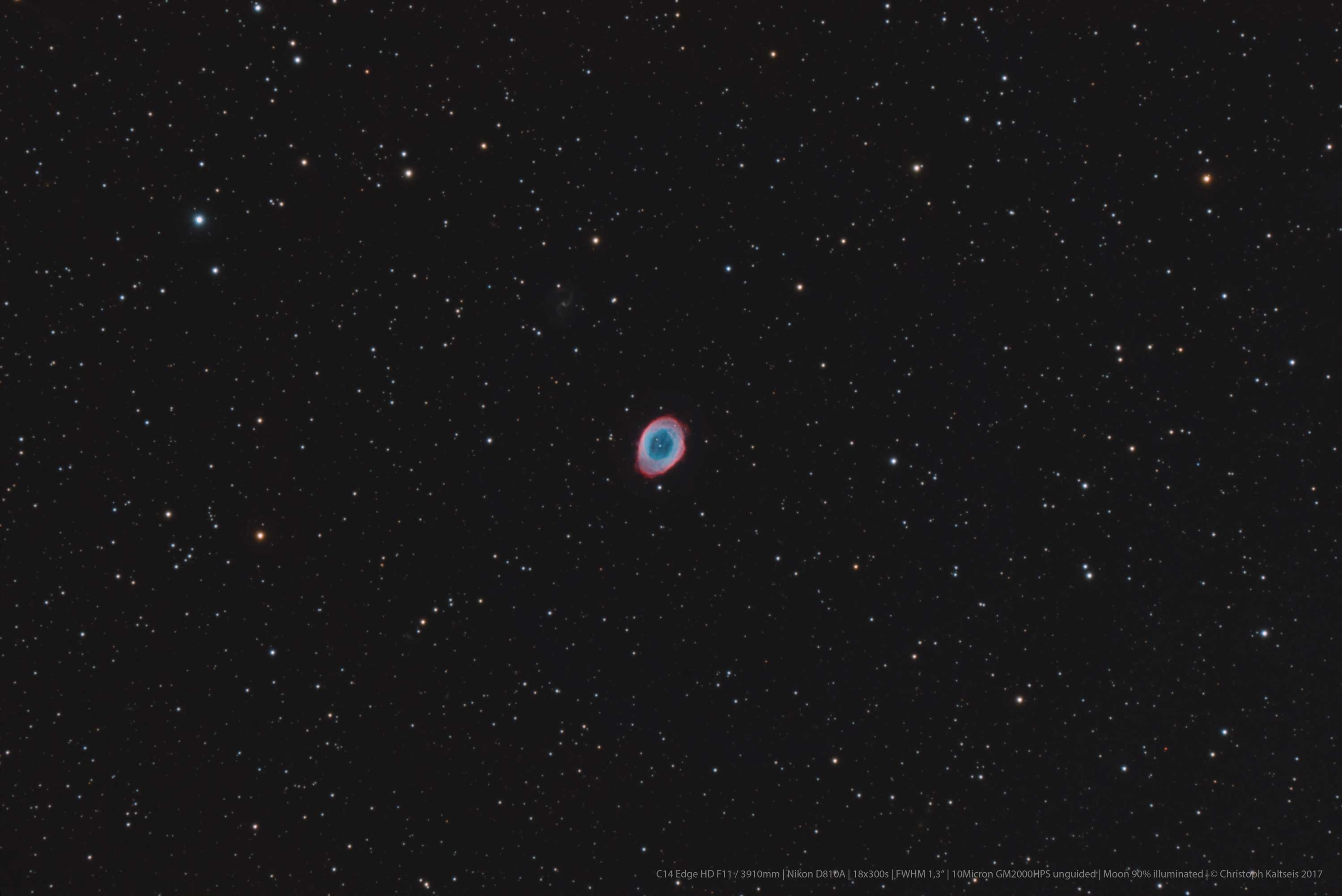 Ein Nebel im Weltraum, ein blauer und roter Ring, umgeben von Sternen.