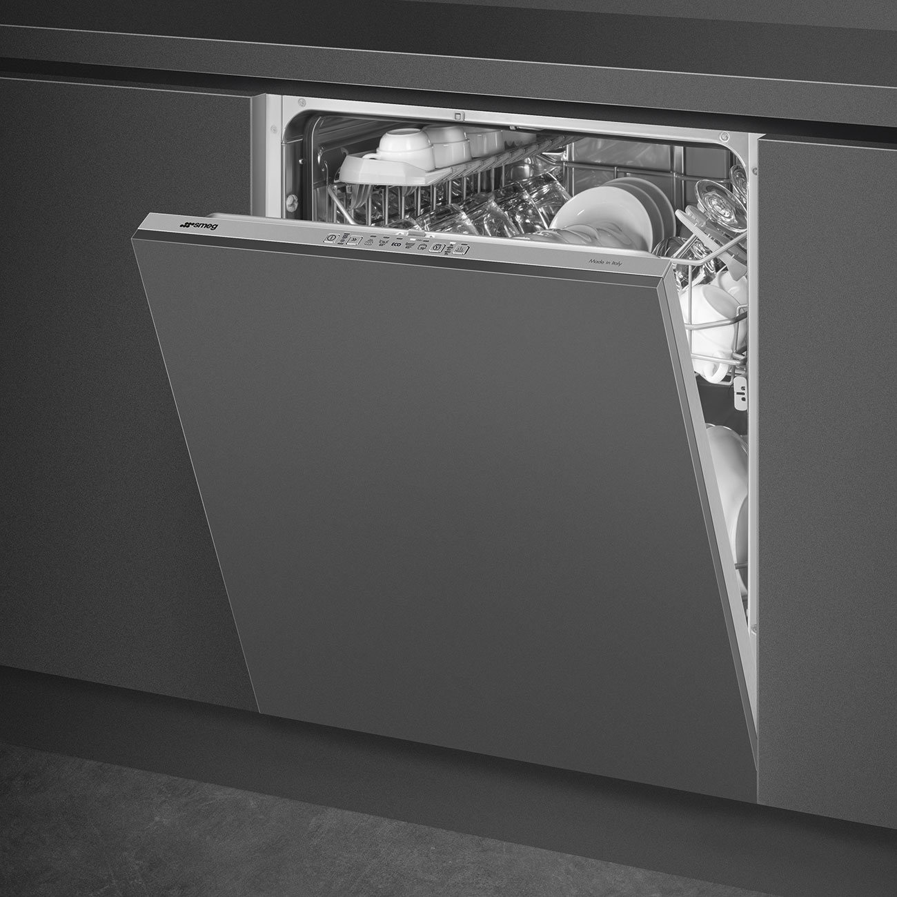 Lavastoviglie Smeg, porta aperta. Esterno grigio scuro, interno con piatti. Cucina integrata.