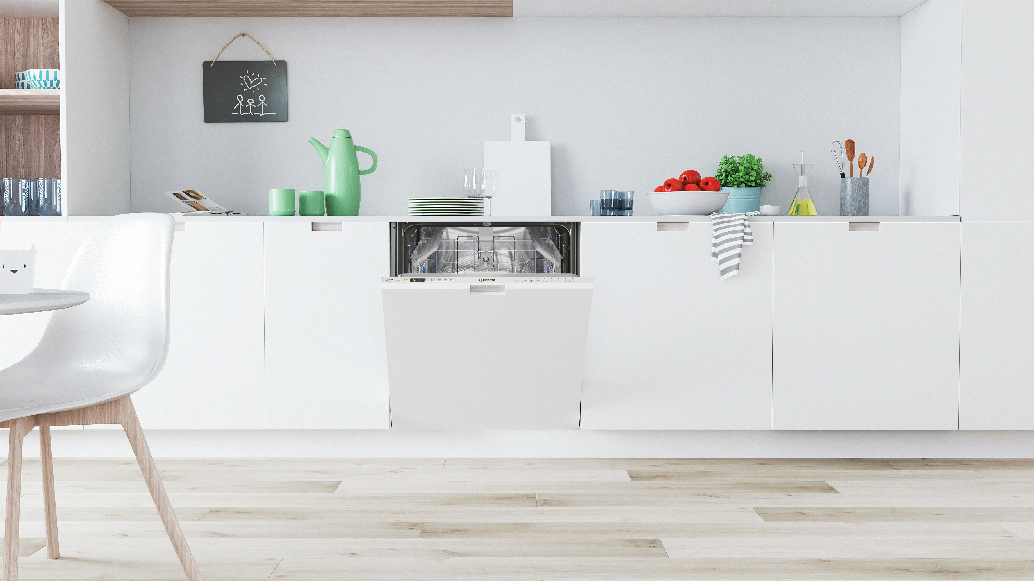 Scena cucina con lavastoviglie Indesit. Piano di lavoro, mobili bianchi e pavimento in legno.