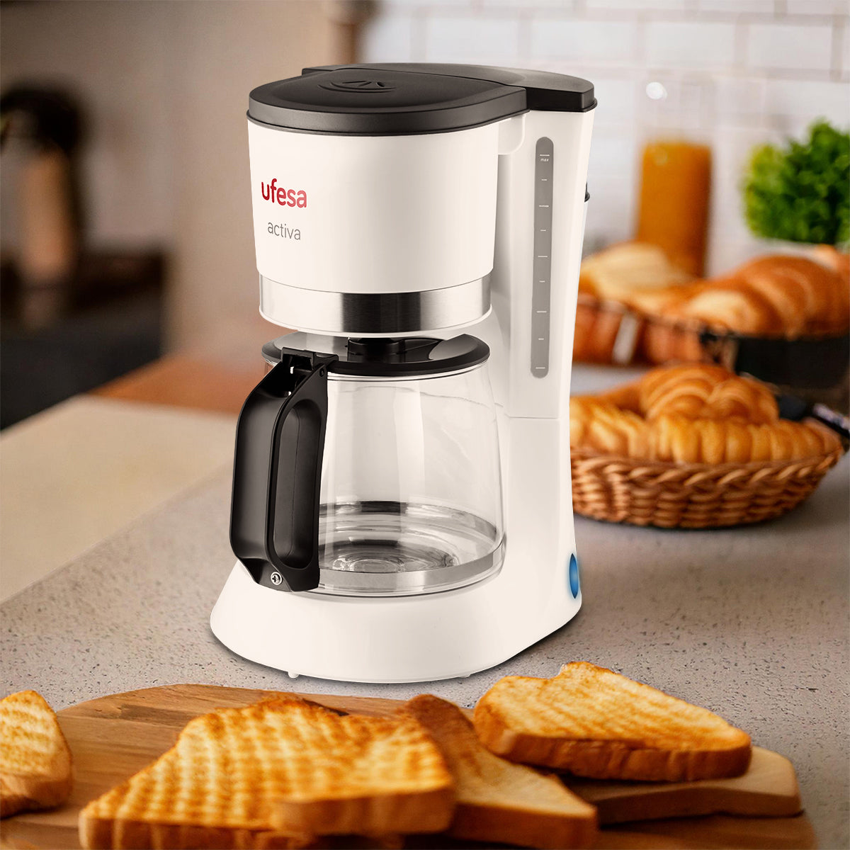 Biały ekspres do kawy Ufesa activa ze szklanym dzbankiem, tostem i chlebem w tle.