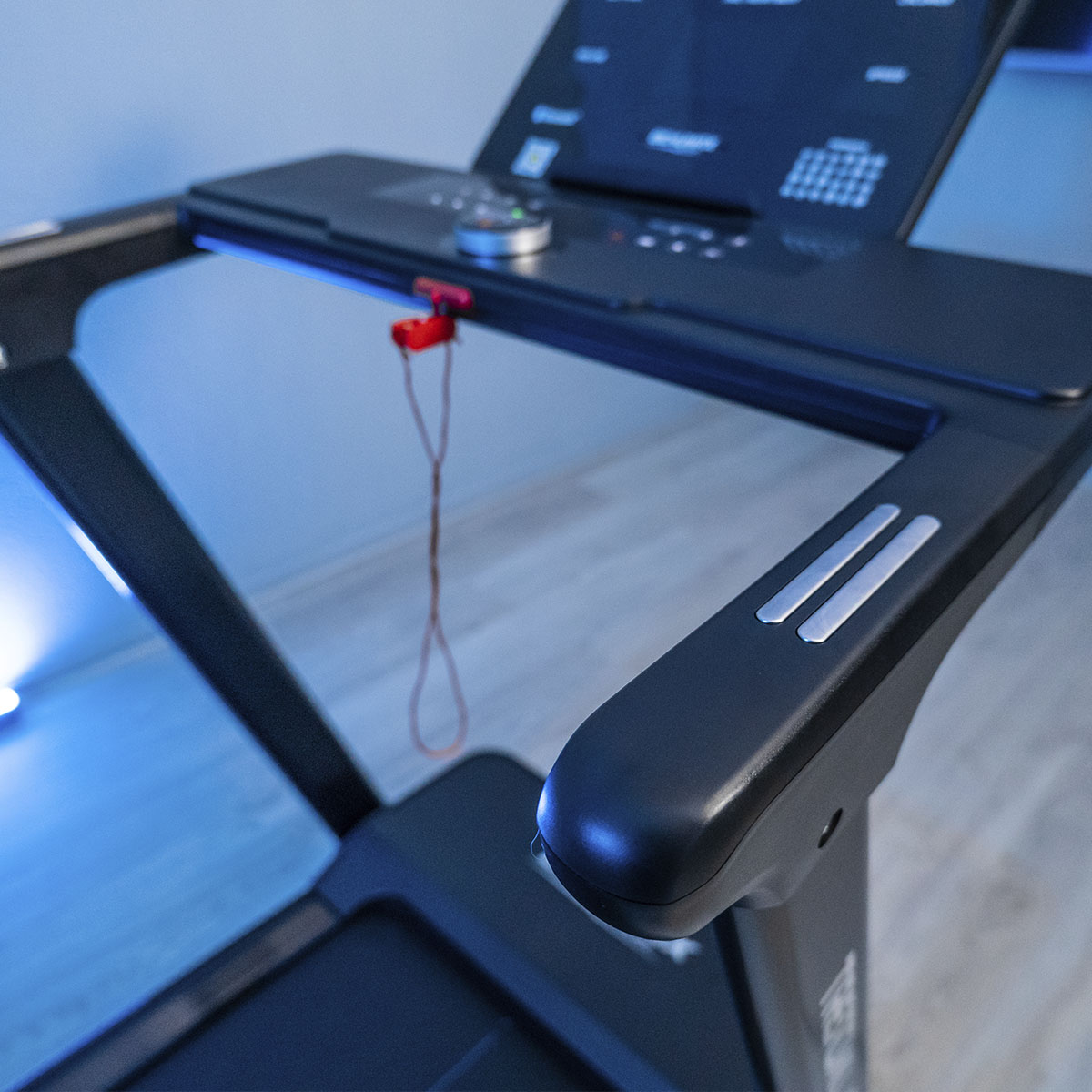 Detalle de la cinta de correr. Muestra el panel de control y los reposabrazos. Detalles metálicos.