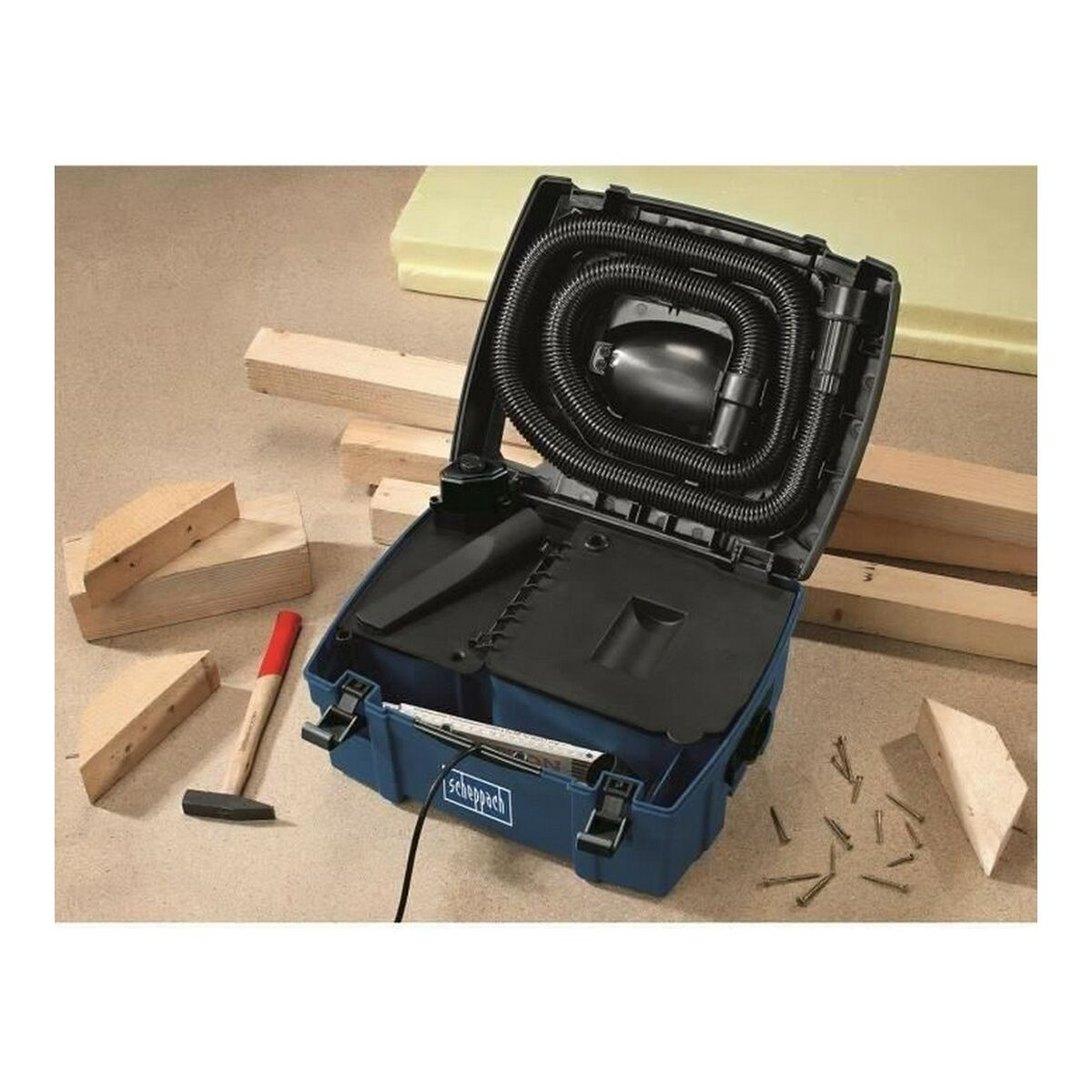 Open blue vacuum cleaner with hose. Hammer and wood pieces are on the left. Screws on the right.