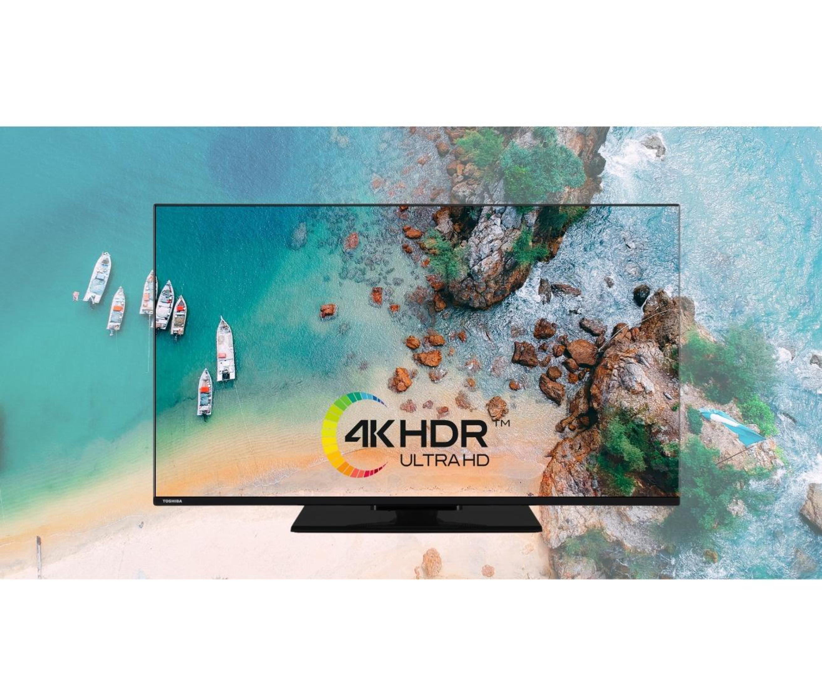 Ein Toshiba-Fernseher zeigt eine Strandszene mit Booten und Wasser. Der Bildschirm zeigt 4K HDR Ultra HD.