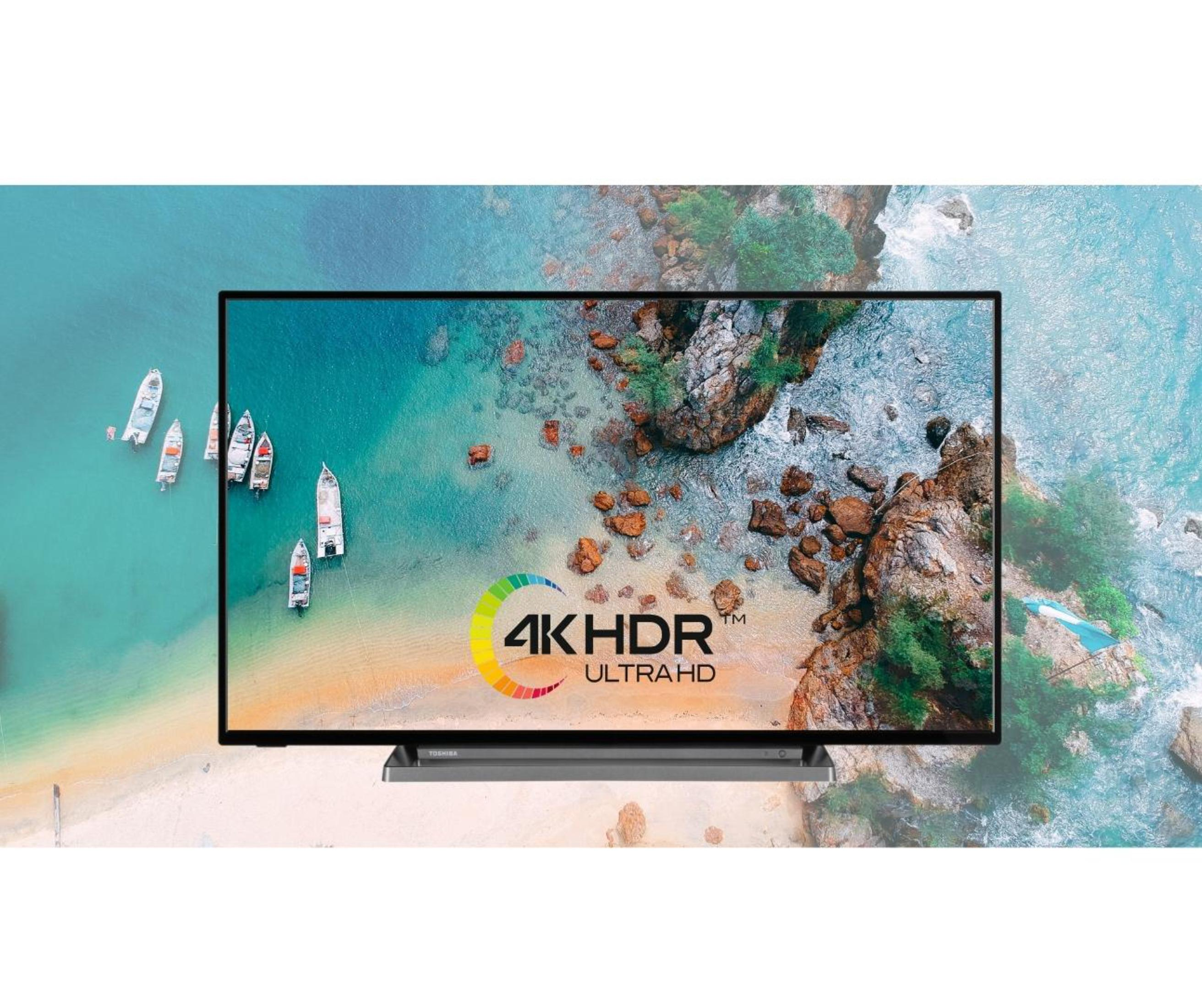 Telewizor wyświetla scenę na plaży z łodziami. Telewizor ma logo Toshiba i tekst 4K HDR Ultra HD.
