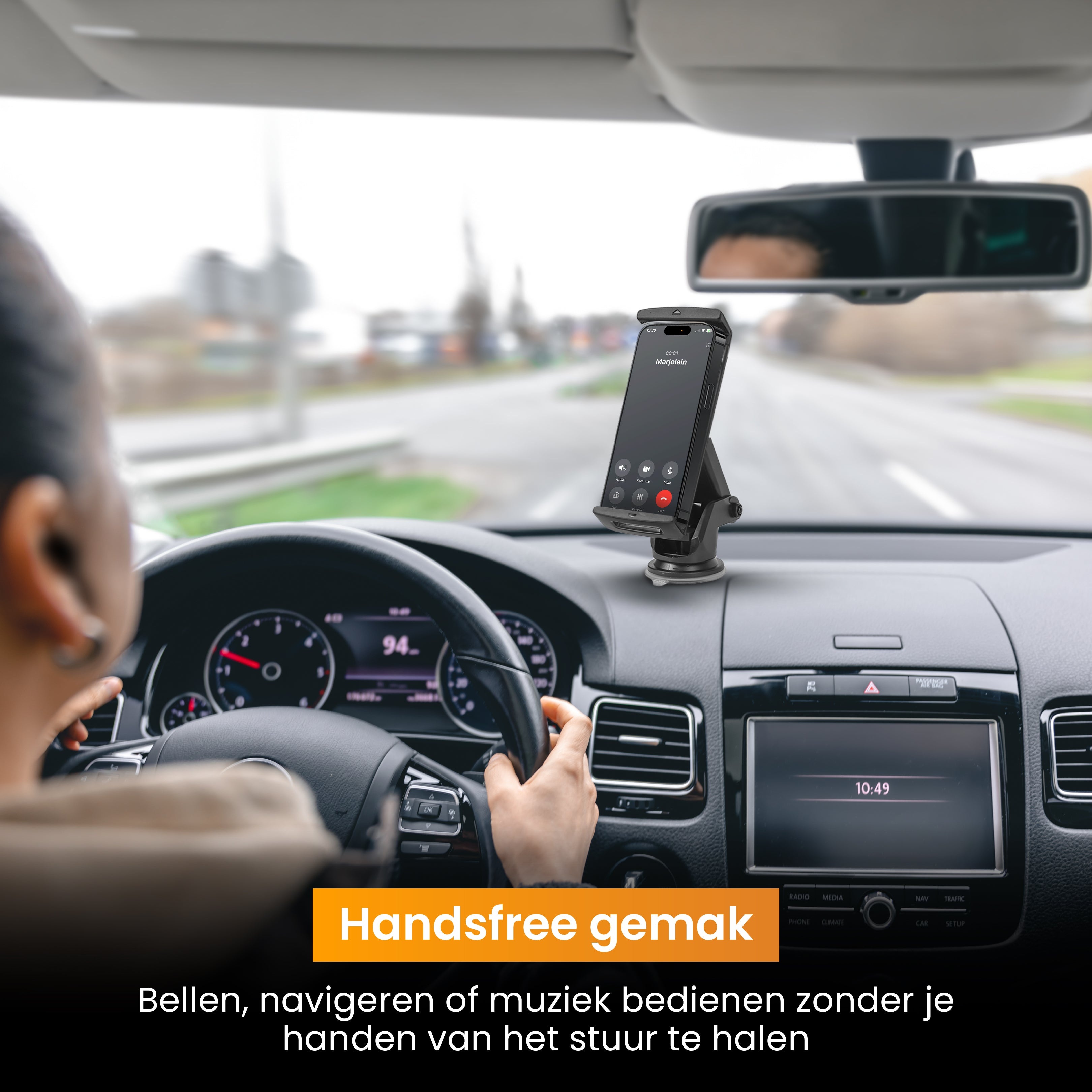 Een telefoon in een autohouder, tekst: Handsfree gemak. Dashboard en stuur zichtbaar.