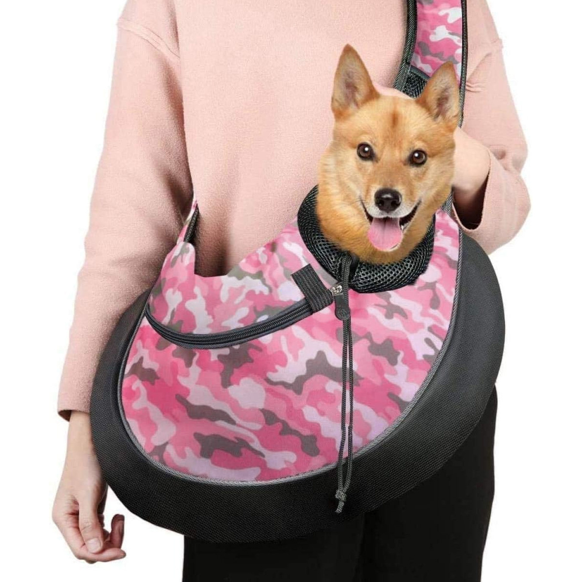 Frau trägt einen Hund in einer rosa Camouflage-Haustiertasche. Kopf des Hundes sichtbar.