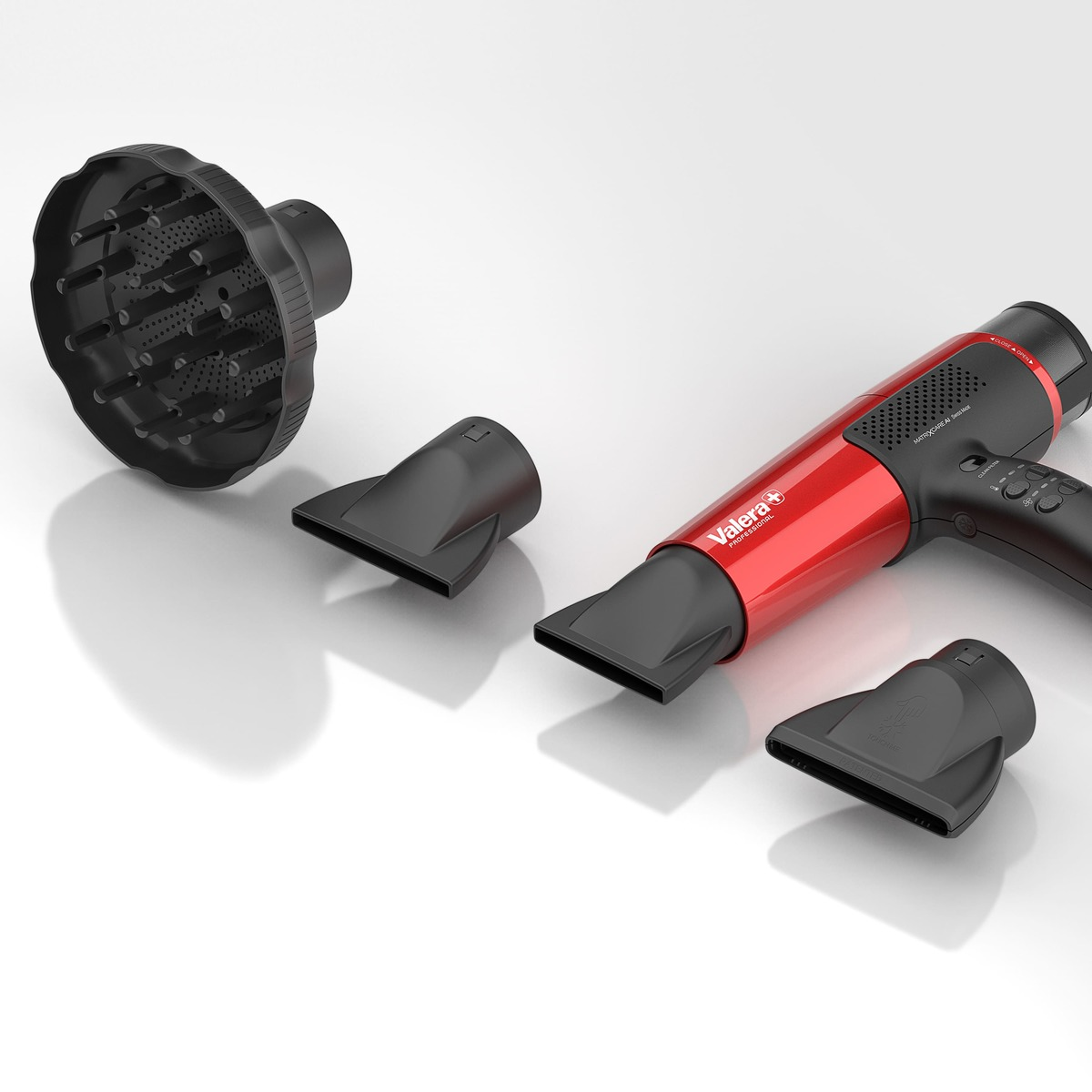 Czerwona i czarna suszarka do włosów z nasadkami, na białym tle.