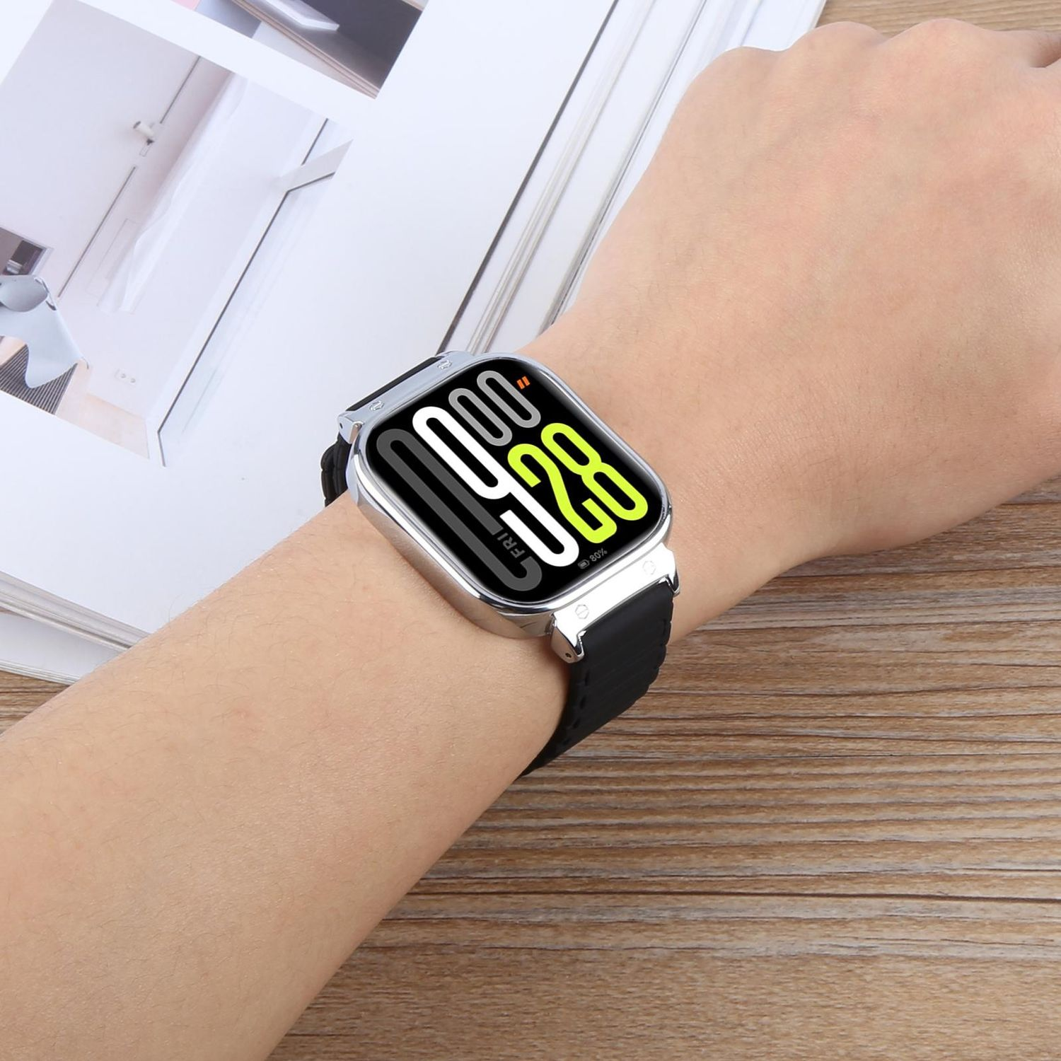 Die Hand einer Person, die eine silberne Uhr mit schwarzem Armband trägt, zeigt Zeit und Datum an.