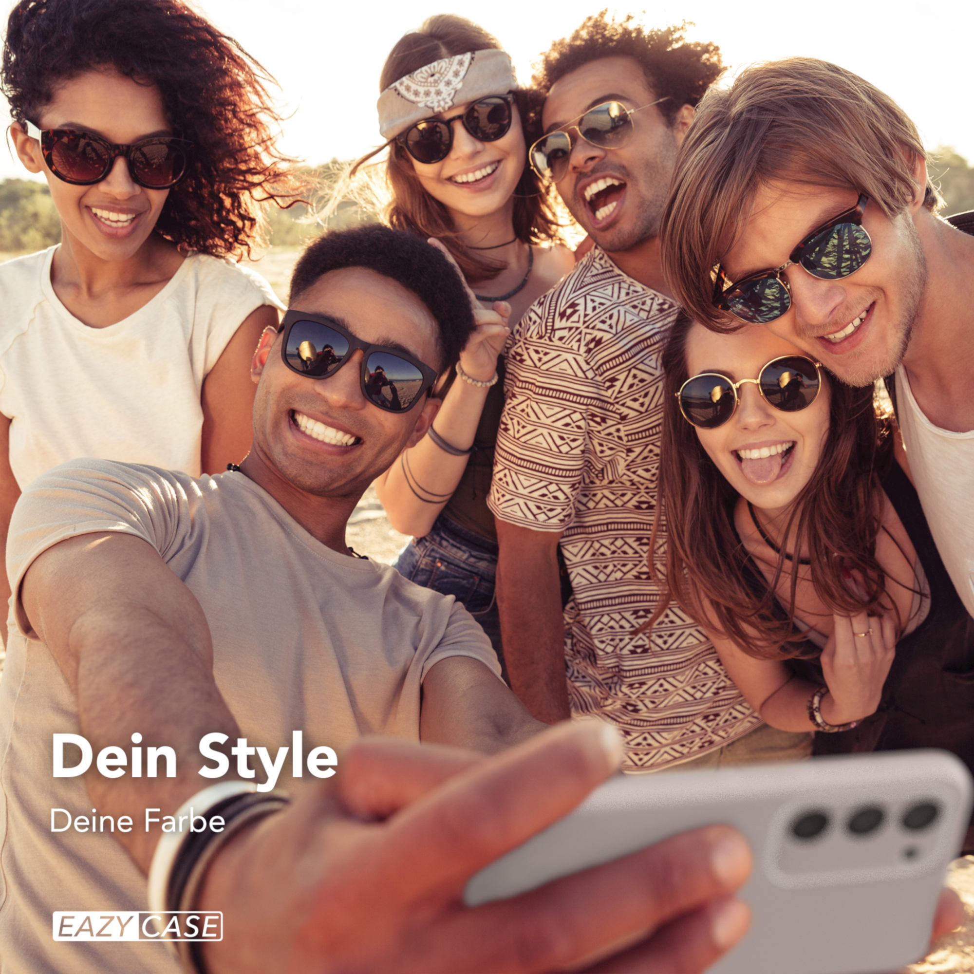 Gruppe von Freunden macht ein Selfie im Freien, alle tragen Sonnenbrillen und lächeln in die Kamera.
