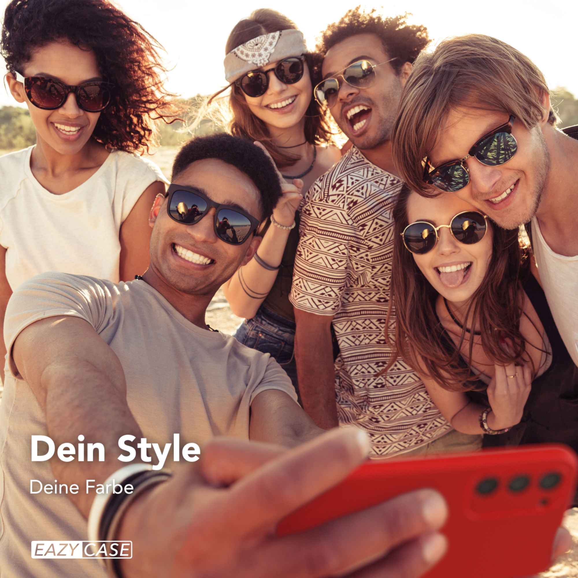 Freundesgruppe macht Selfie im Freien mit roter Handyhülle. Sonnenbrillen werden getragen. Sonnenlicht.