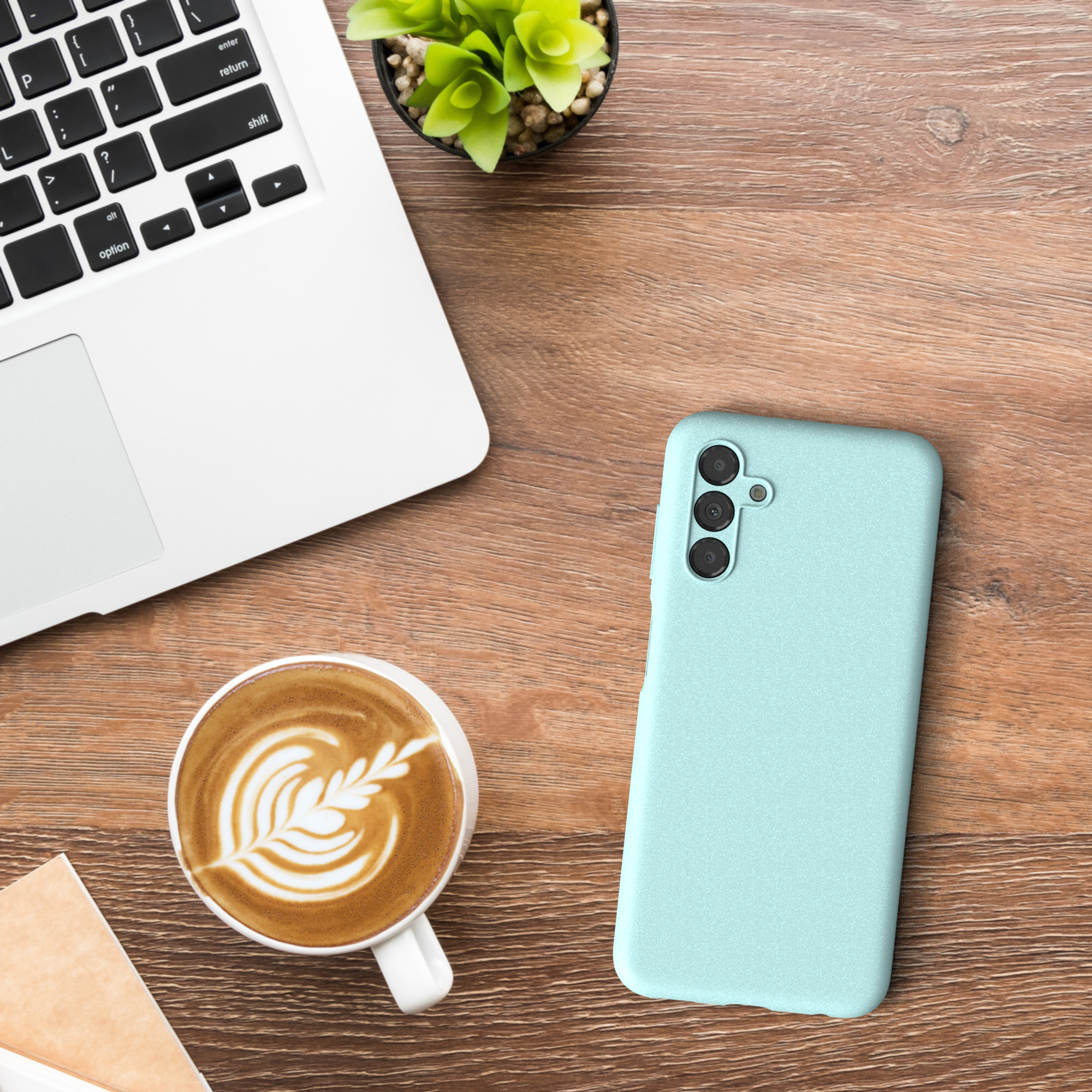 Ein Laptop, ein Telefon und eine Tasse Kaffee auf einem Holztisch.