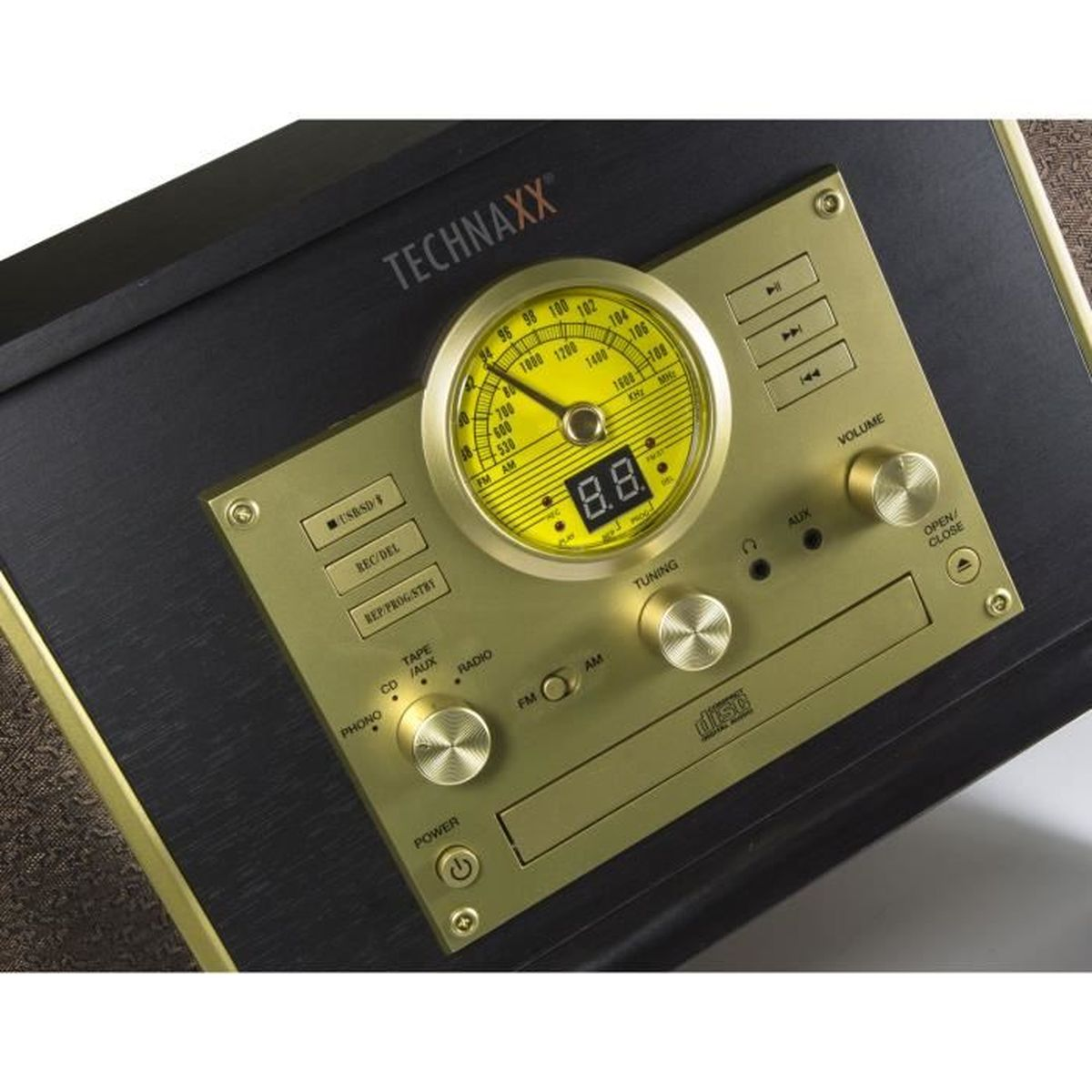 Primo piano di una radio retrò con la facciata dorata. Ha manopole, un quadrante di sintonia e un display digitale.