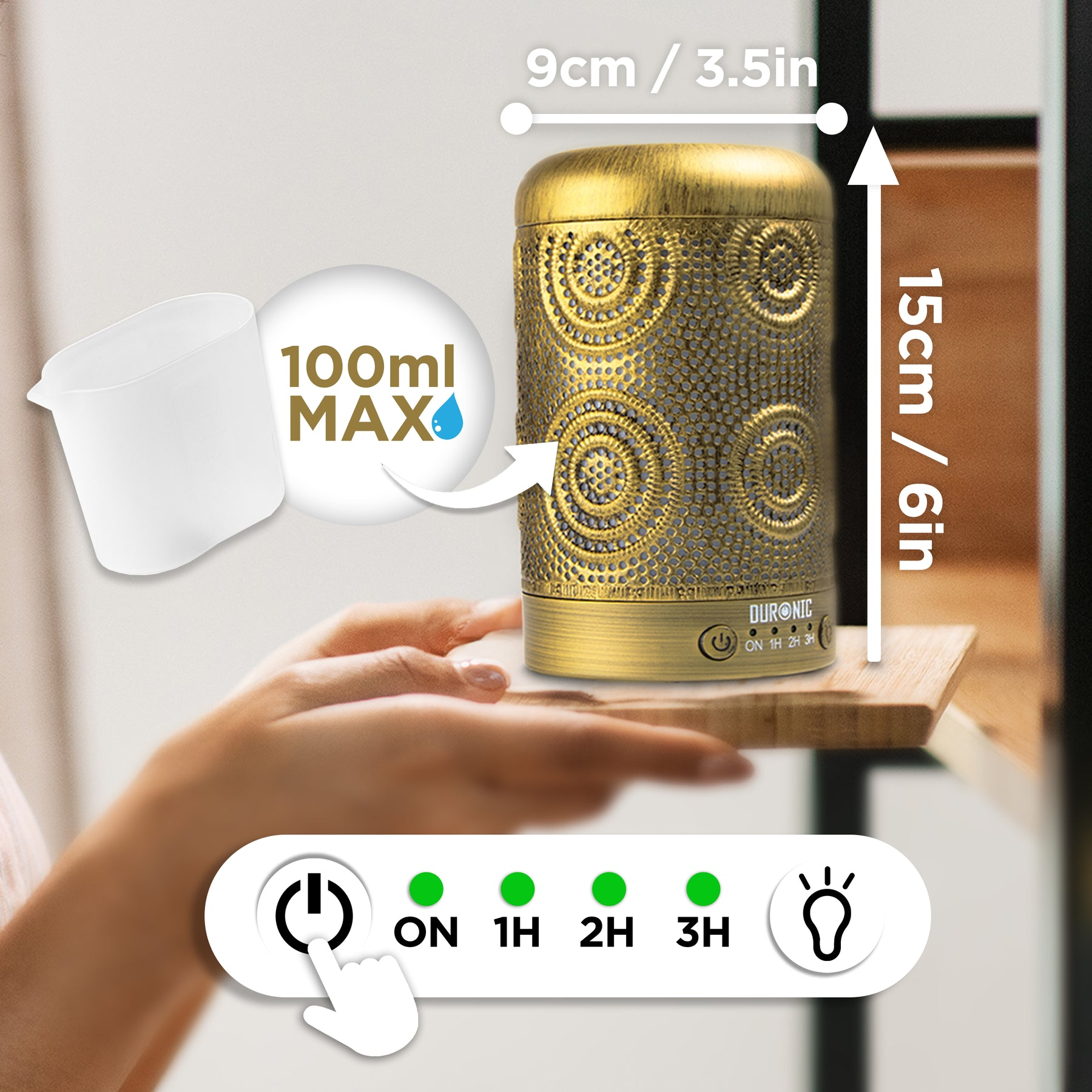 Ein goldfarbener Aromadiffusor auf einer Holzoberfläche. Er hat Knöpfe und Maße.