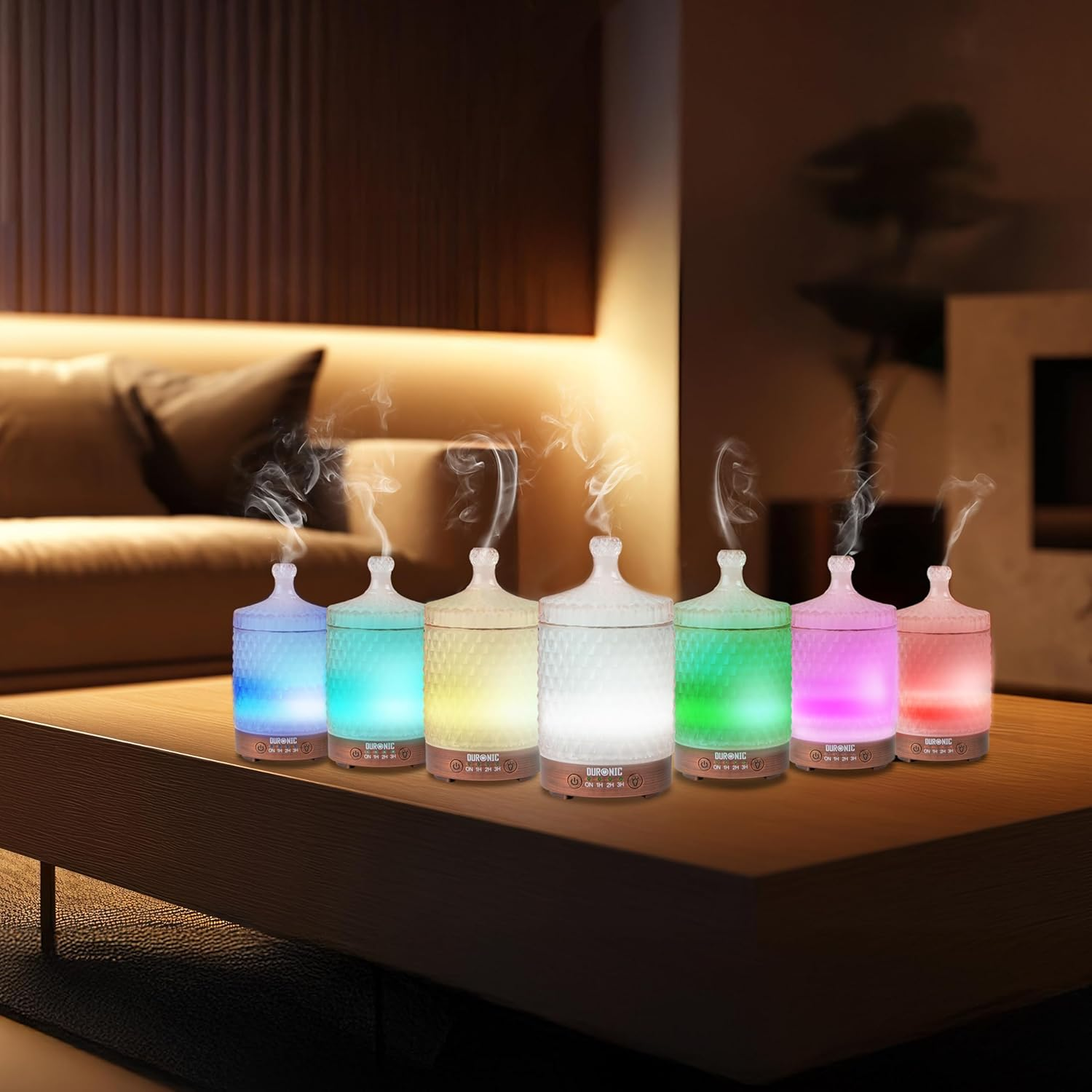 Sechs bunte Aromadiffusoren auf einem Tisch. Sie haben jeweils unterschiedliche Farben.