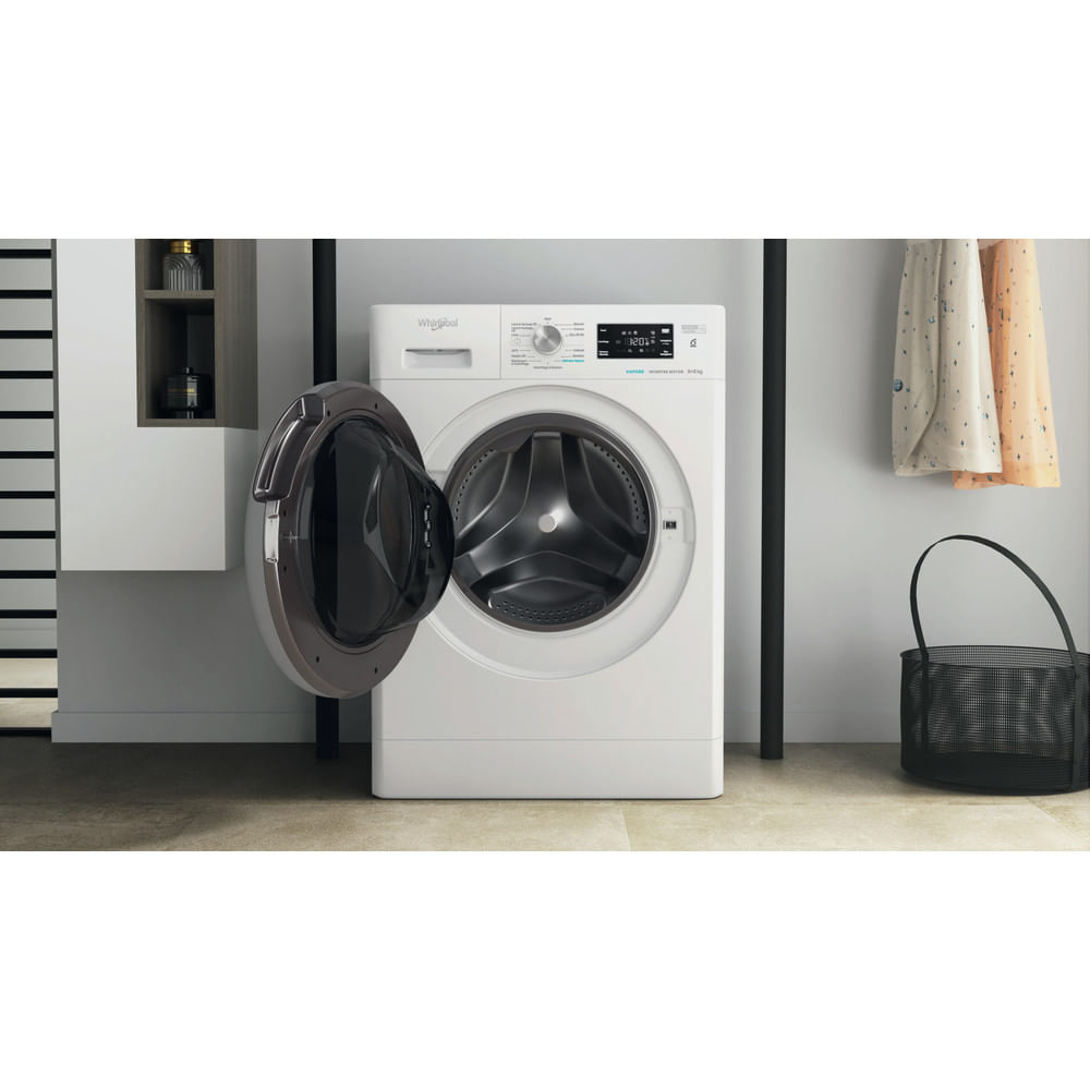 Una lavatrice Whirlpool bianca con la porta aperta. Un ambiente lavanderia.