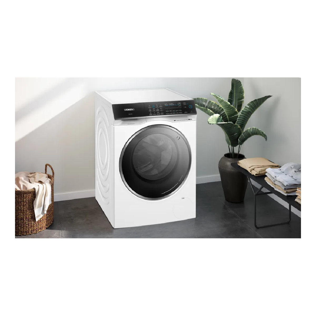 Weiße Siemens-Waschmaschine in einer Raumsituation, mit Wäschekorb und Pflanzen.