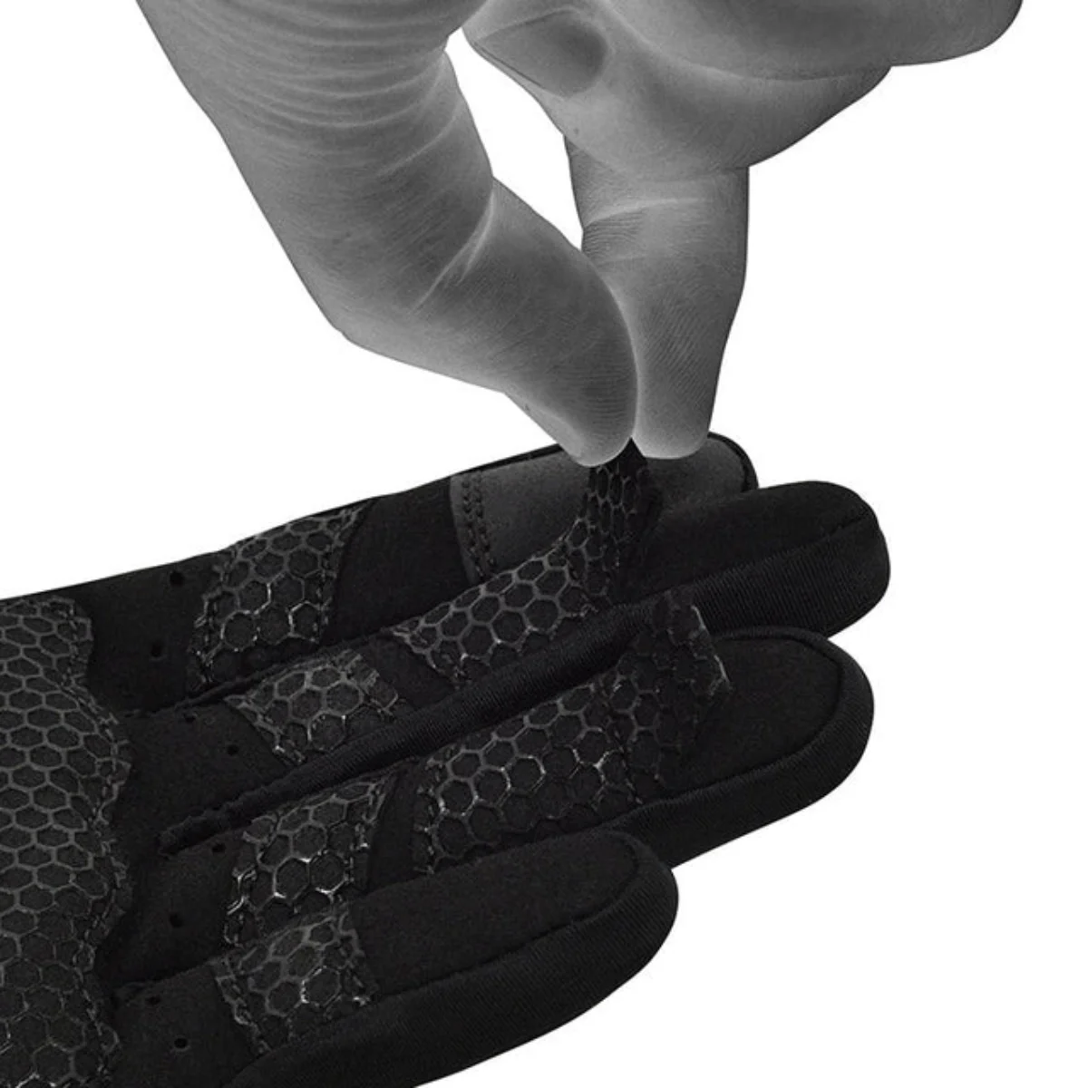 Gros plan sur une main en train de décoller une couche de gants d'entraînement noirs, montrant le motif en nid d'abeille.