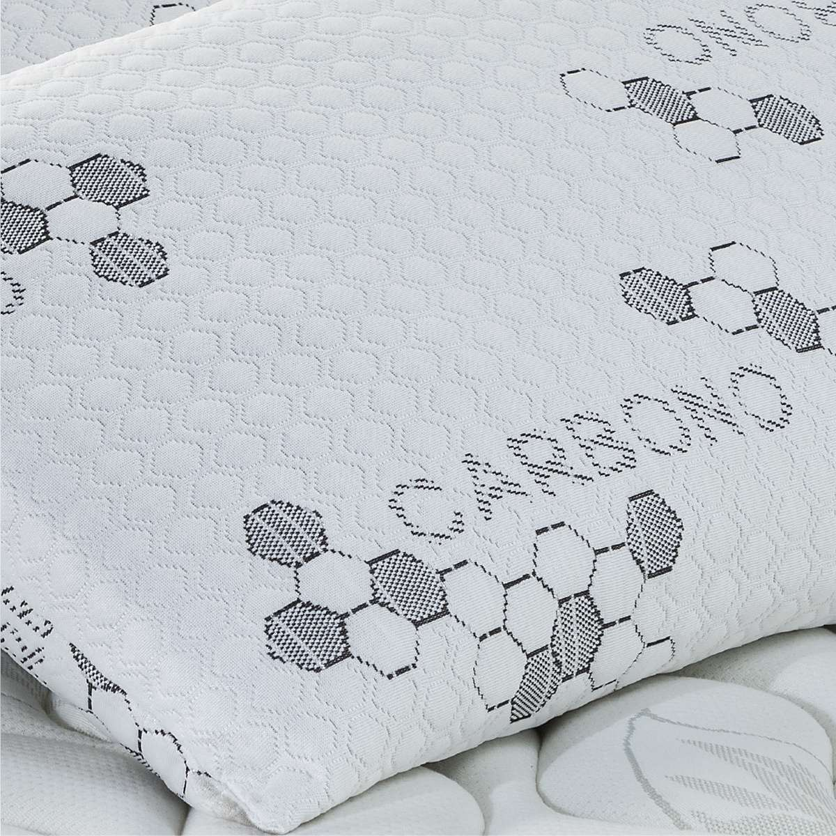 Almohada blanca con un patrón de panal y la palabra 'CARBONO'.