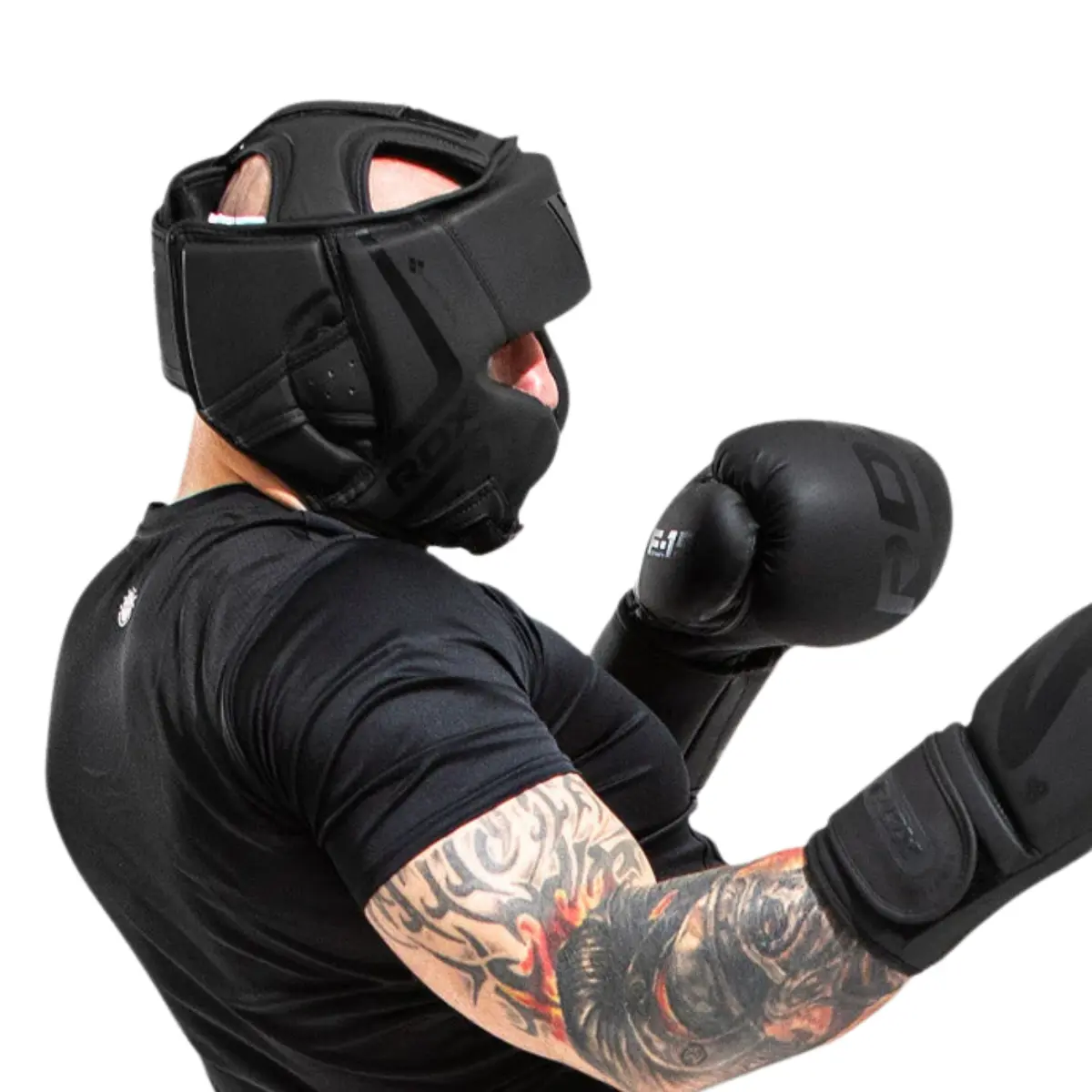 Boxer wearing black headgear, gloves, and shirt, in a fighting stance.