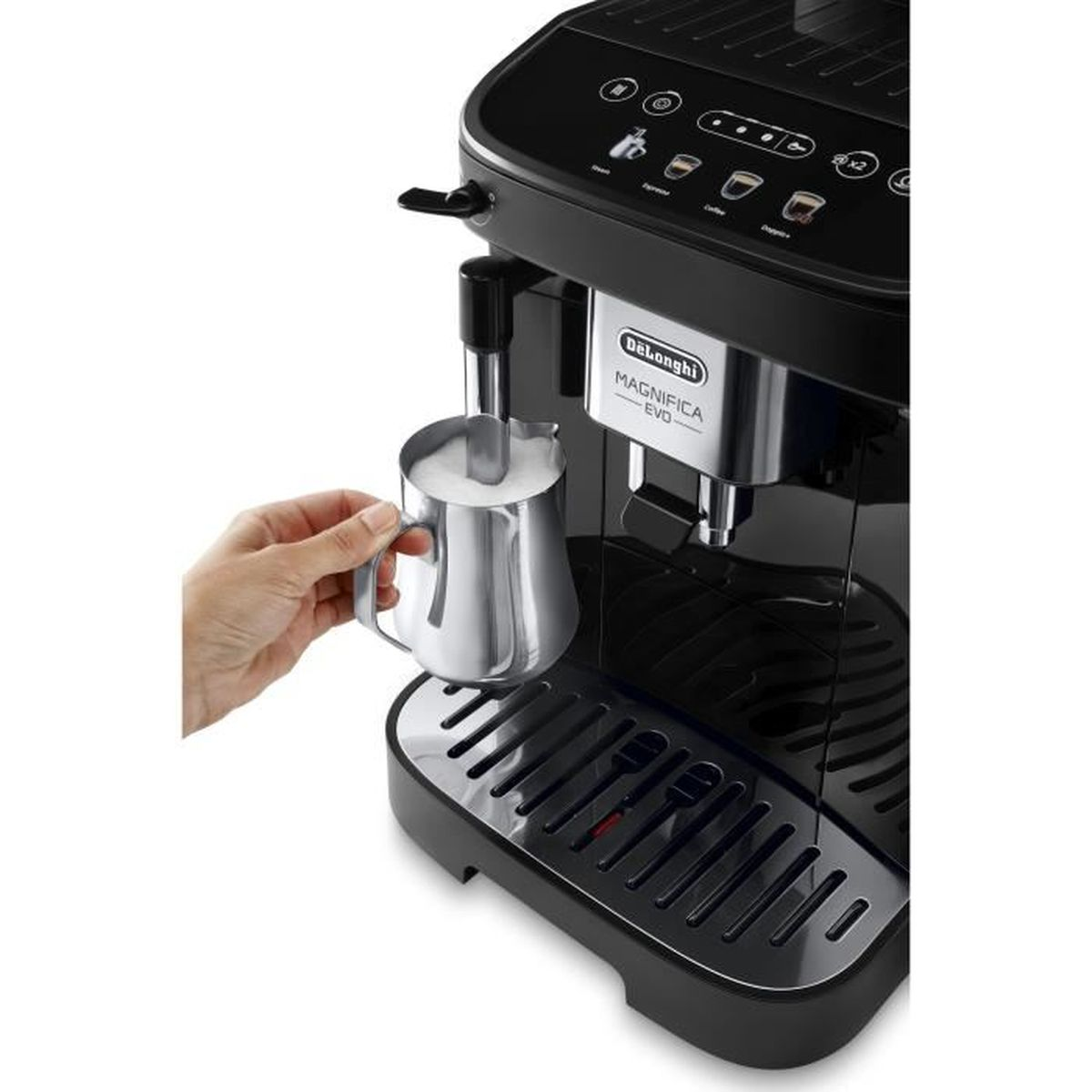 A person's hand holding a milk frothing pitcher next to a black De'Longhi coffee machine.