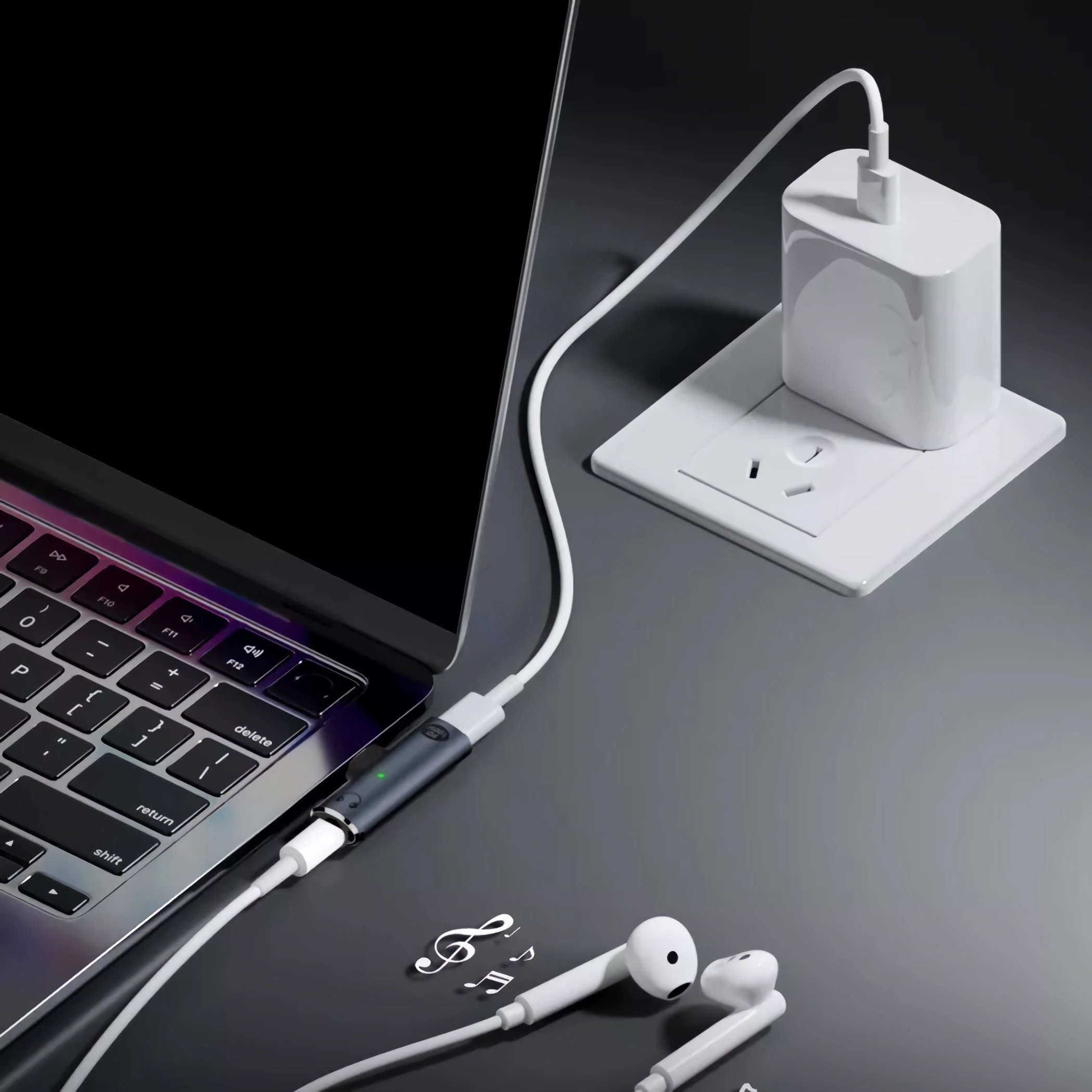 Ein Laptop ist über ein Kabel mit einem Ladegerät verbunden. Kopfhörer sind ebenfalls angeschlossen.