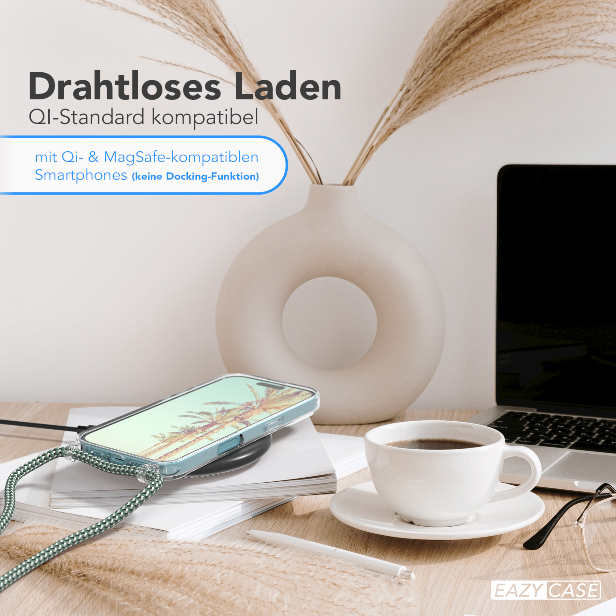 Ein Telefon, das auf einem kabellosen Pad geladen wird, neben einer Kaffeetasse und einem Laptop.