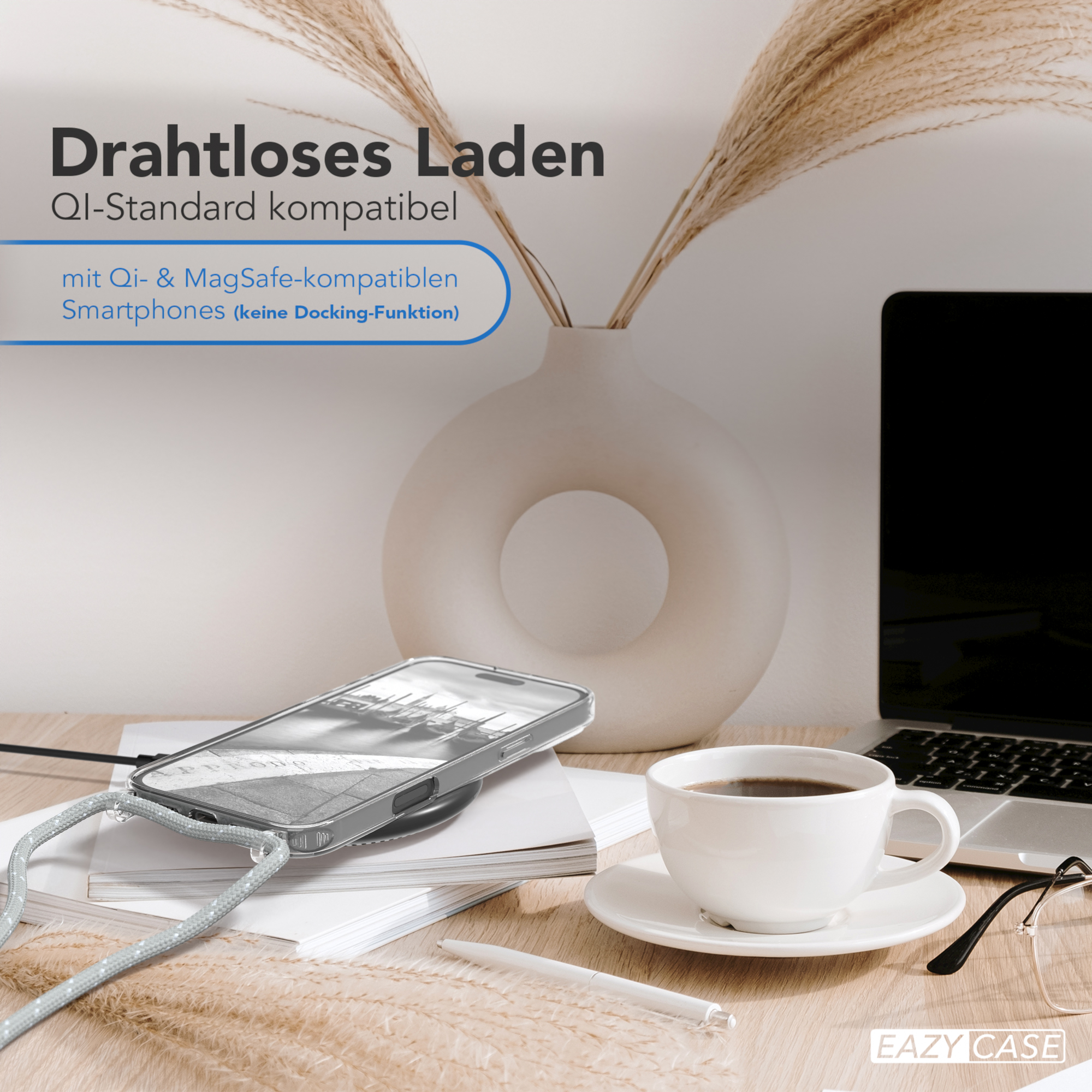 Kabelloses Lade-Setup mit einem Telefon und einem Qi-kompatiblen Ladegerät. Eine Kaffeetasse steht auf dem Tisch.