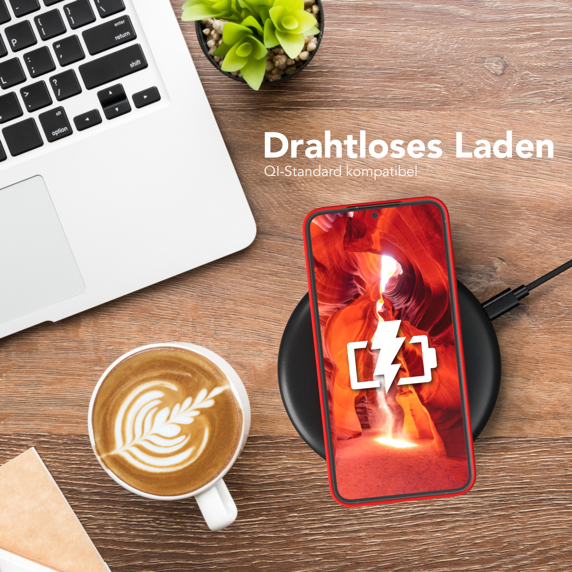 Ein Telefon, das drahtlos geladen wird. Eine Tasse Kaffee und ein Laptop stehen auf dem Tisch.