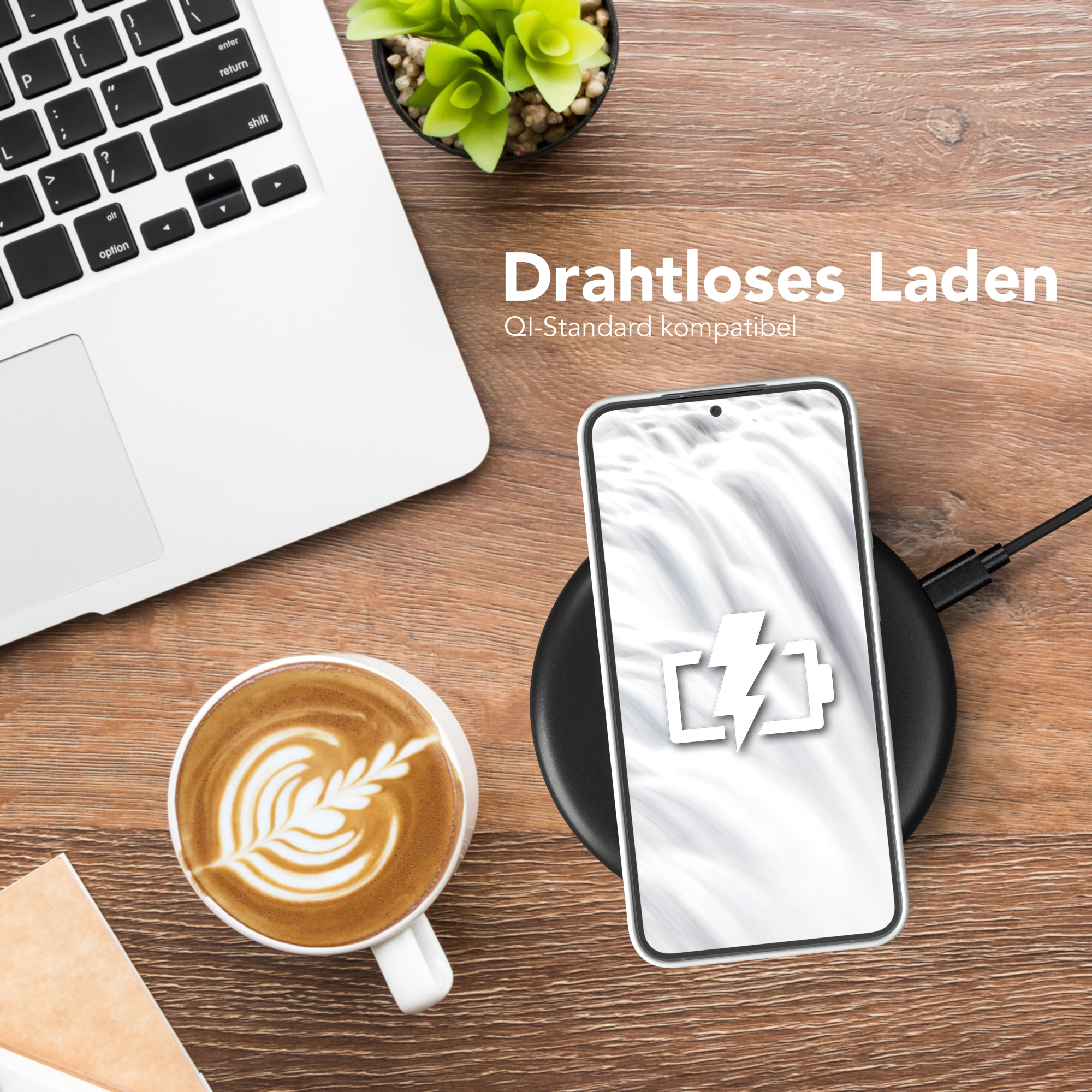 Telefon wird drahtlos auf einem schwarzen Pad aufgeladen, neben einer Kaffeetasse mit Latte Art, auf einem Holztisch.