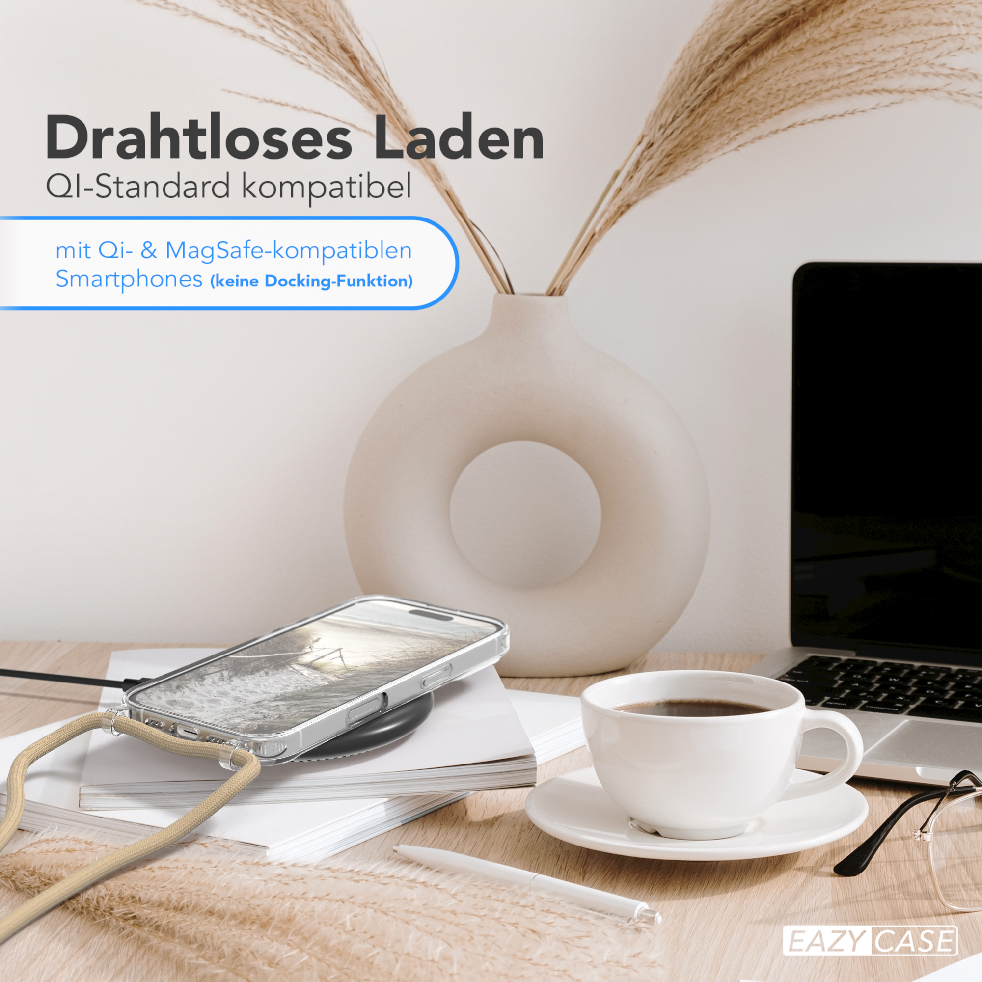 Ein Telefon auf einem kabellosen Ladegerät, eine Tasse Kaffee und eine Vase mit Pflanzen auf einem Holztisch.
