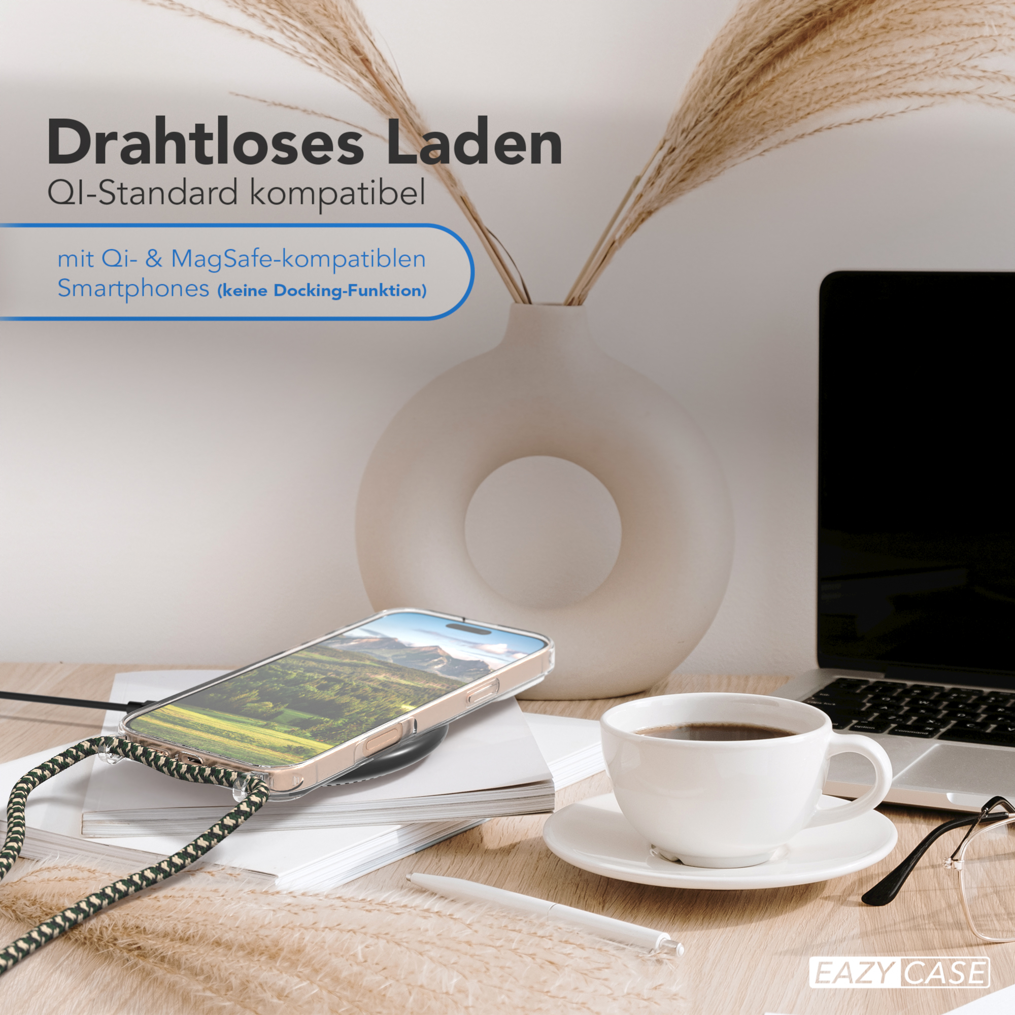 Ein Telefon, das auf einem Schreibtisch aufgeladen wird, eine weiße Vase mit Pflanzen und eine Kaffeetasse.