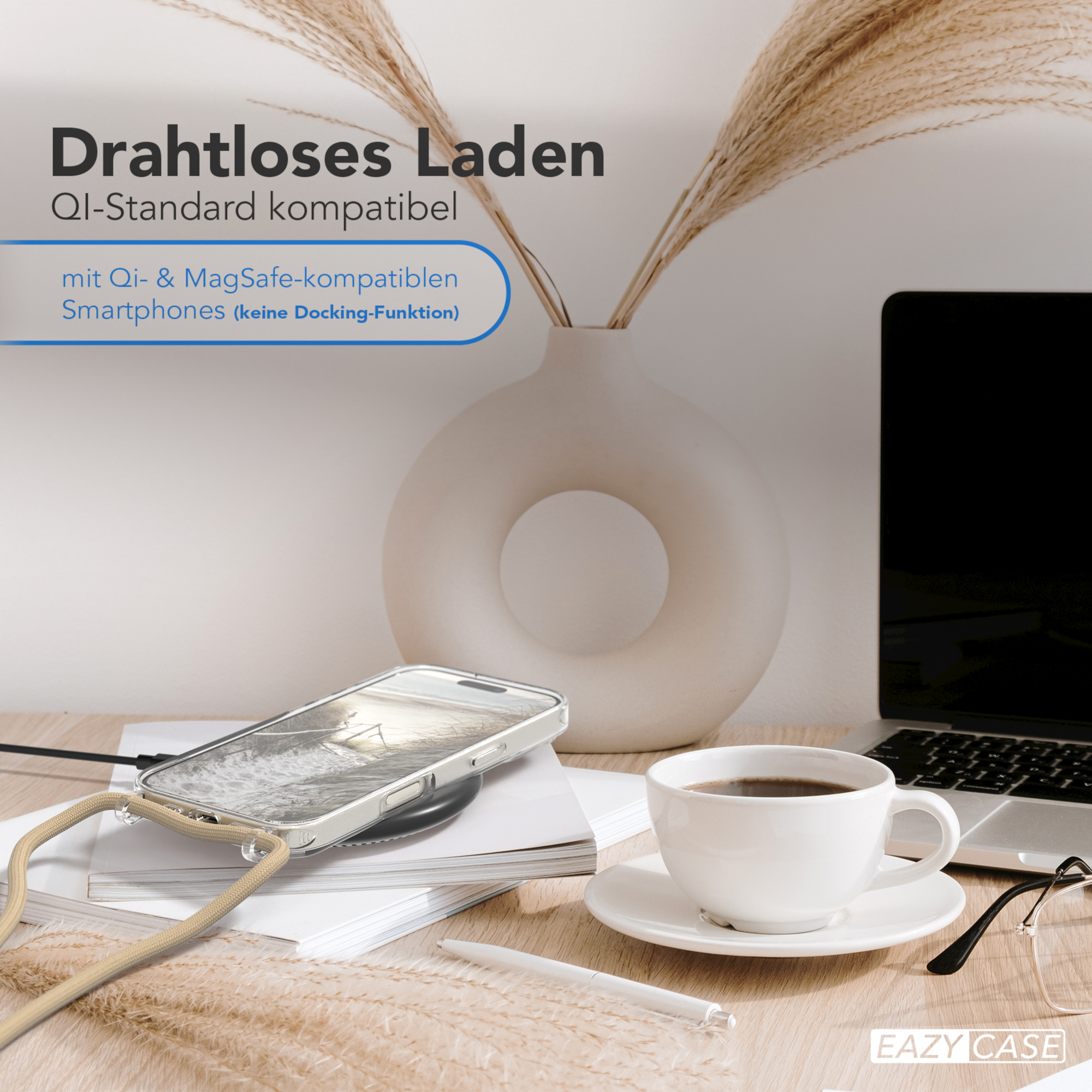 Ein Telefon, das drahtlos geladen wird, mit einem Laptop, Blumen und einer Tasse Kaffee.