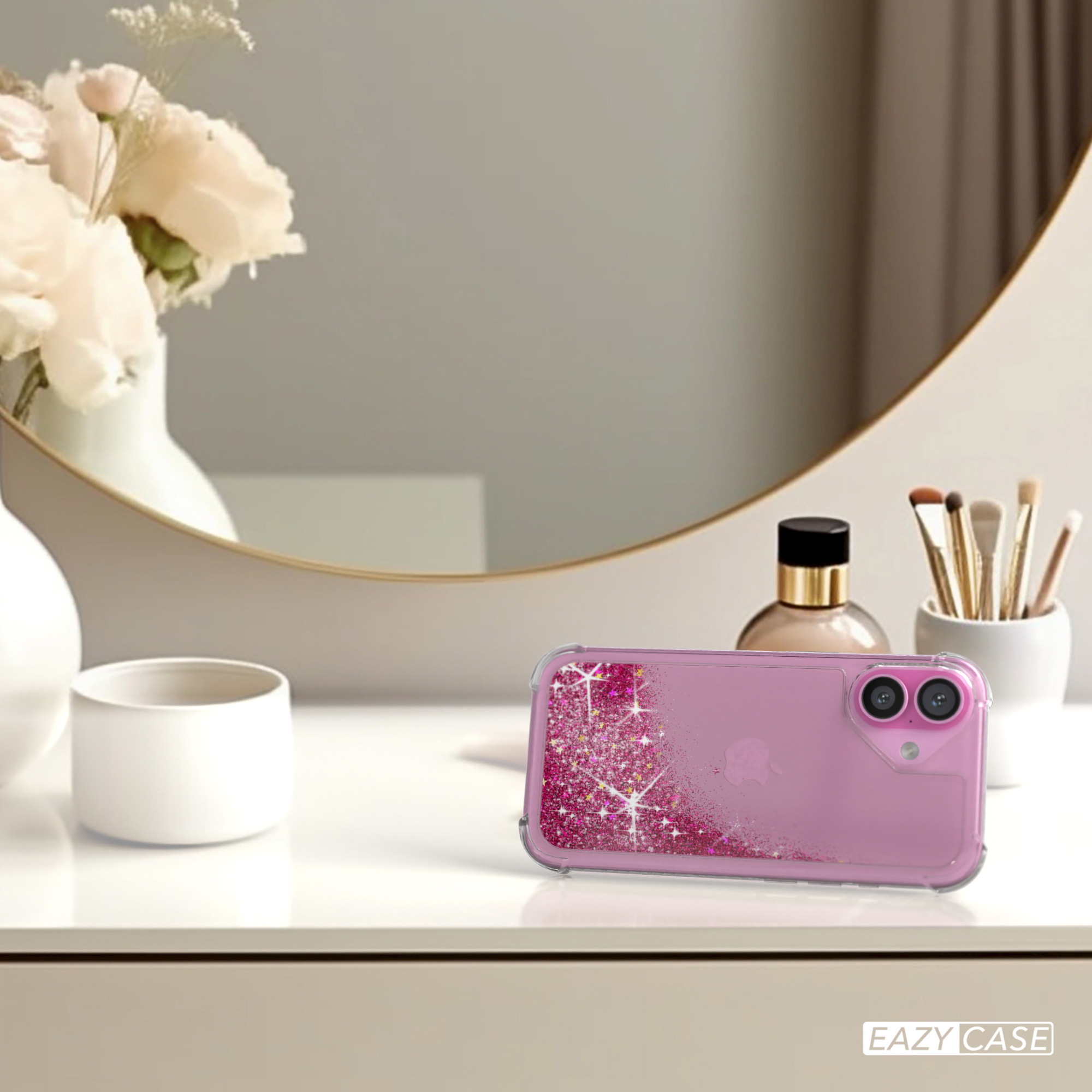 Eine pinkfarbene Handyhülle mit Glitzer liegt auf einem weißen Tisch, im Hintergrund ein Spiegel.