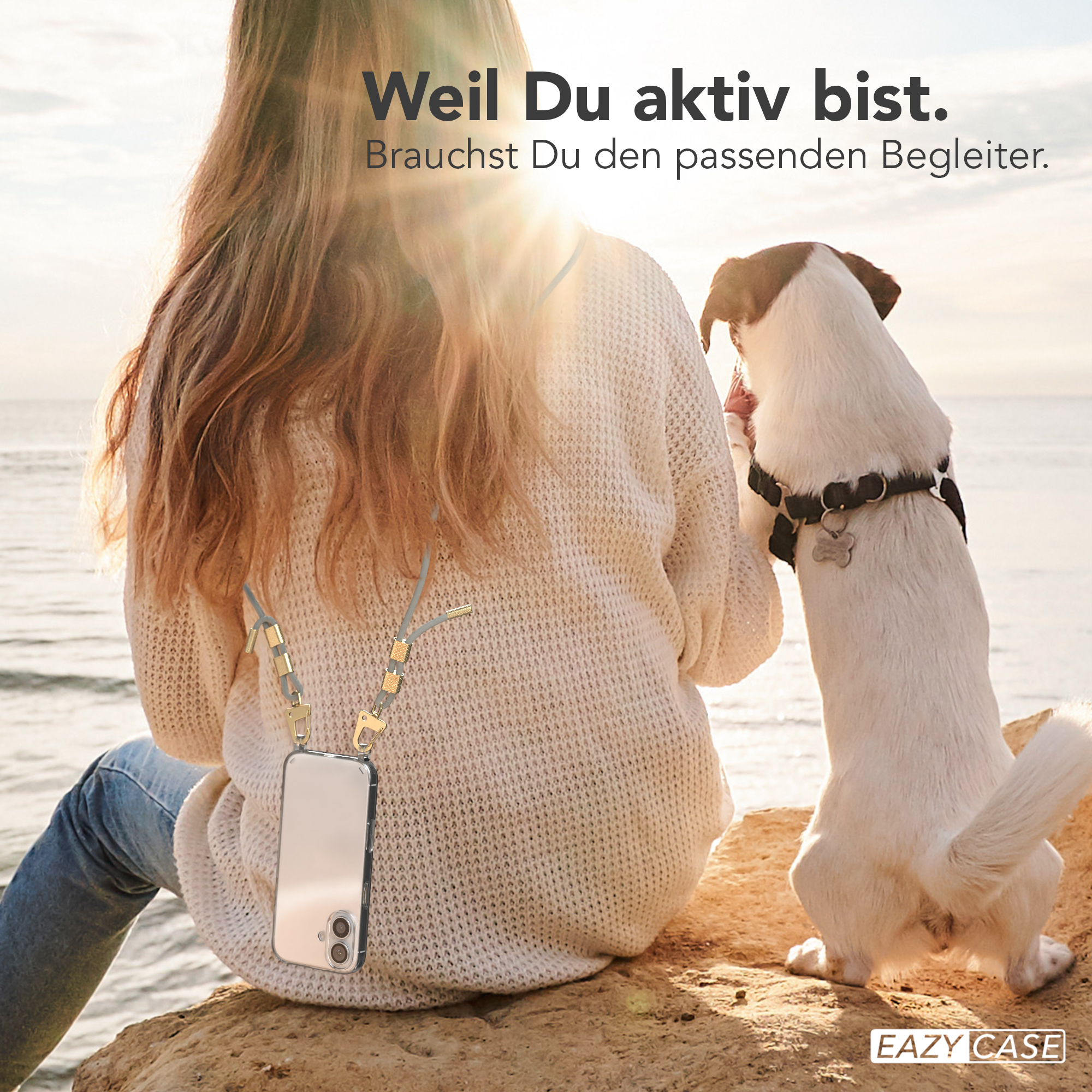 Frau mit langen Haaren, Hund. Frau sitzt auf einem Felsen, Hund steht neben ihr, sonniger Tag.