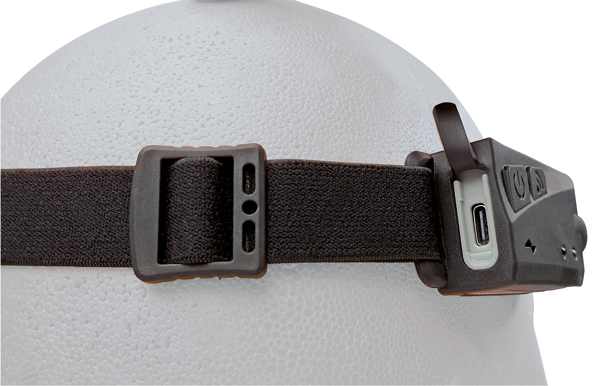 Stirnlampe auf einem Kopf, mit schwarzem Riemen und USB-C-Anschluss.