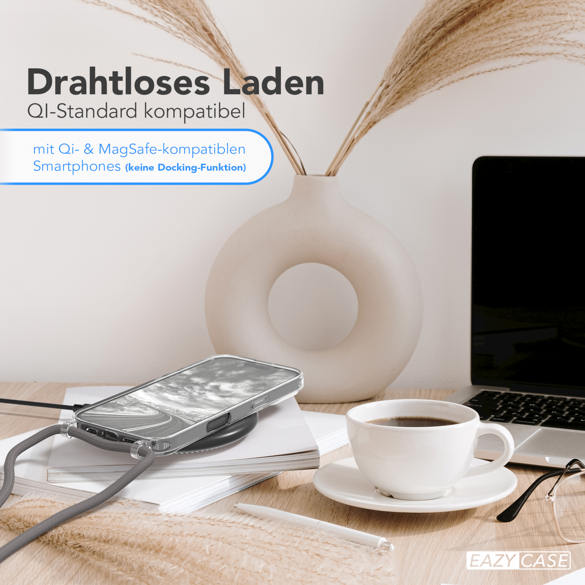 Ein Telefon auf einem kabellosen Ladegerät, mit einer Tasse Kaffee und Gläsern; der Hintergrund ist unscharf.