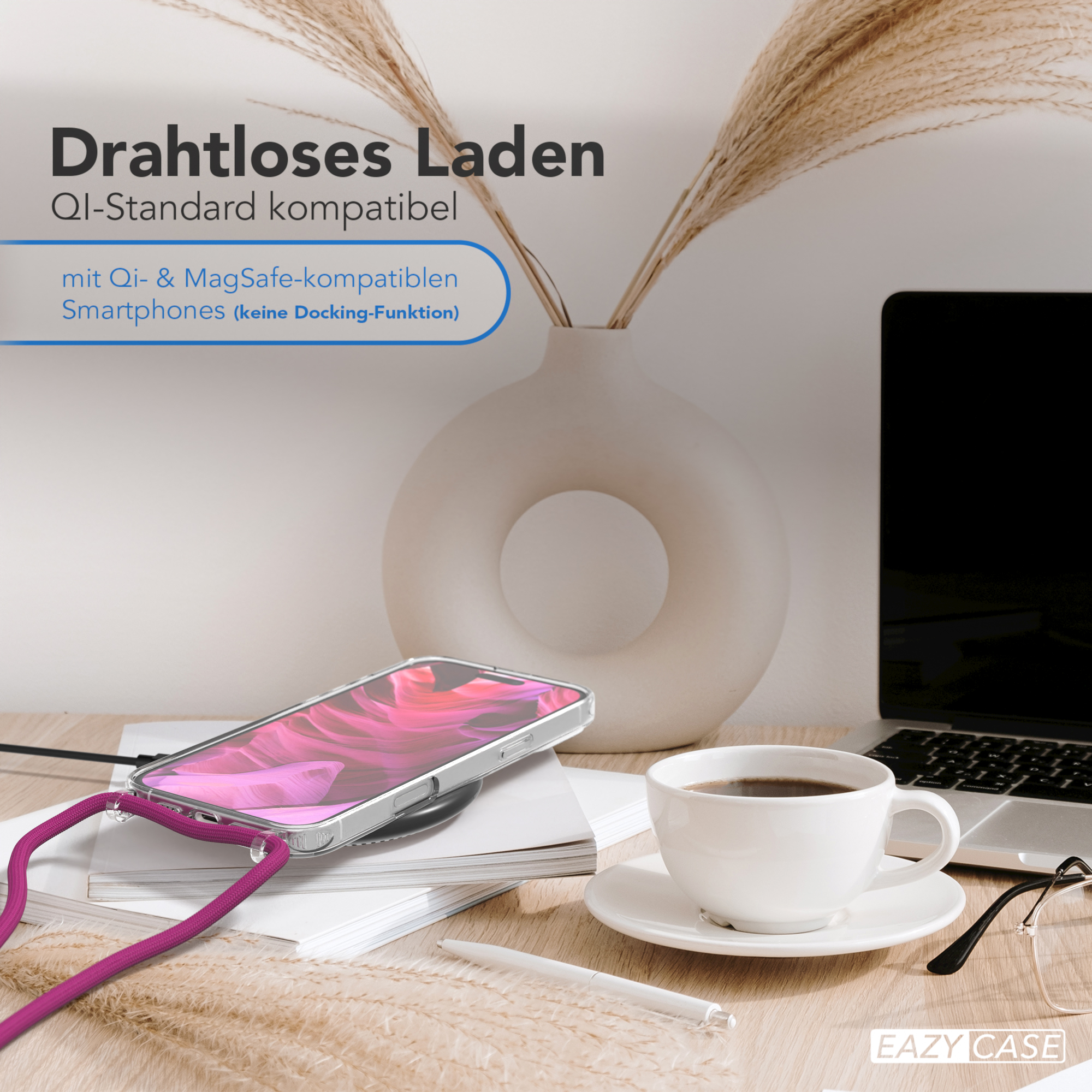 Telefon mit Hülle, der auf einem kabellosen Ladegerät lädt. Neben einer Kaffeetasse, einem Laptop und einer Brille.