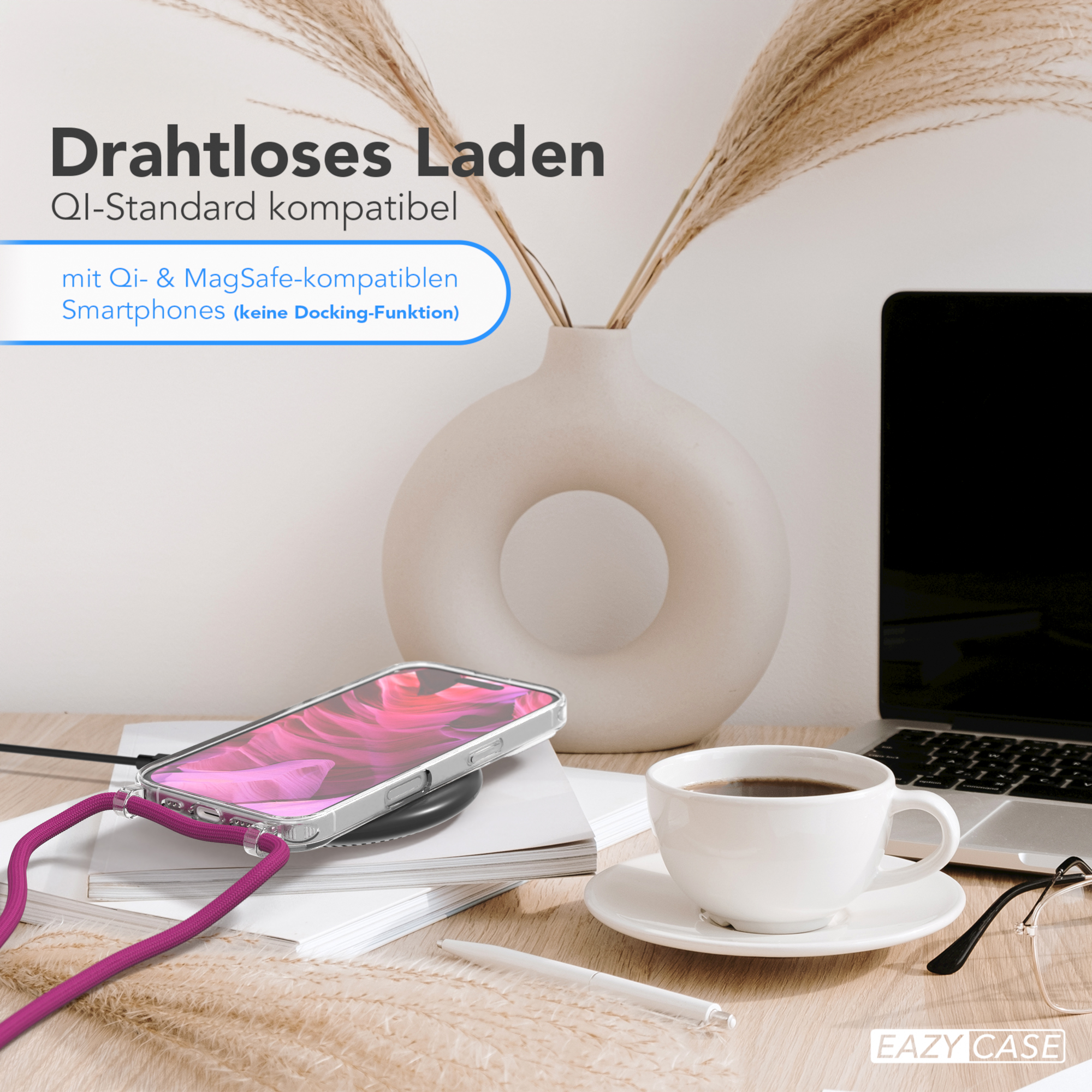 Ein Telefon auf einem kabellosen Ladegerät, neben einer Tasse Kaffee und einem Laptop auf einem Schreibtisch.