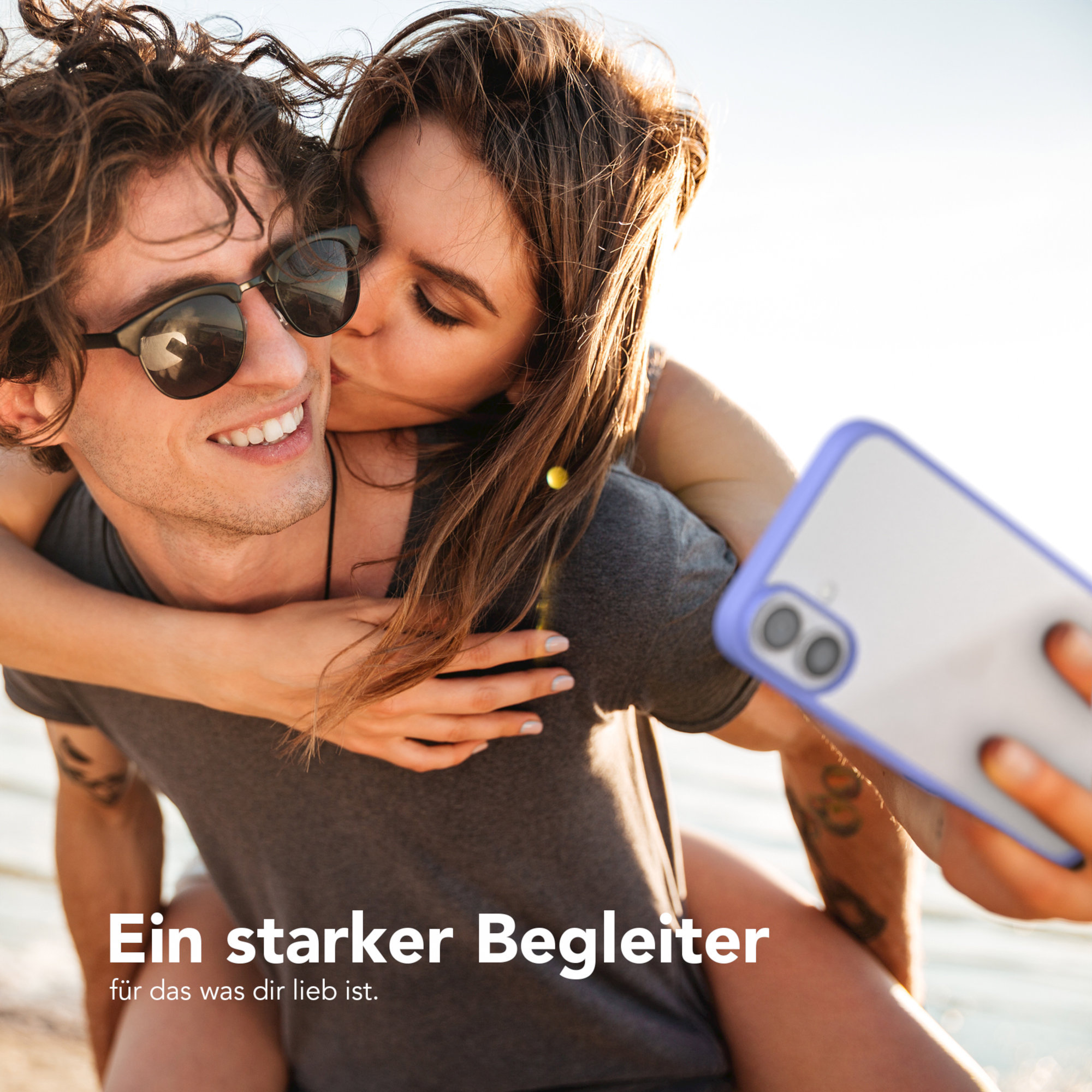 Mann und Frau umarmen sich, küssen sich. Mann hält ein Handy. Text: Ein starker Begleiter.